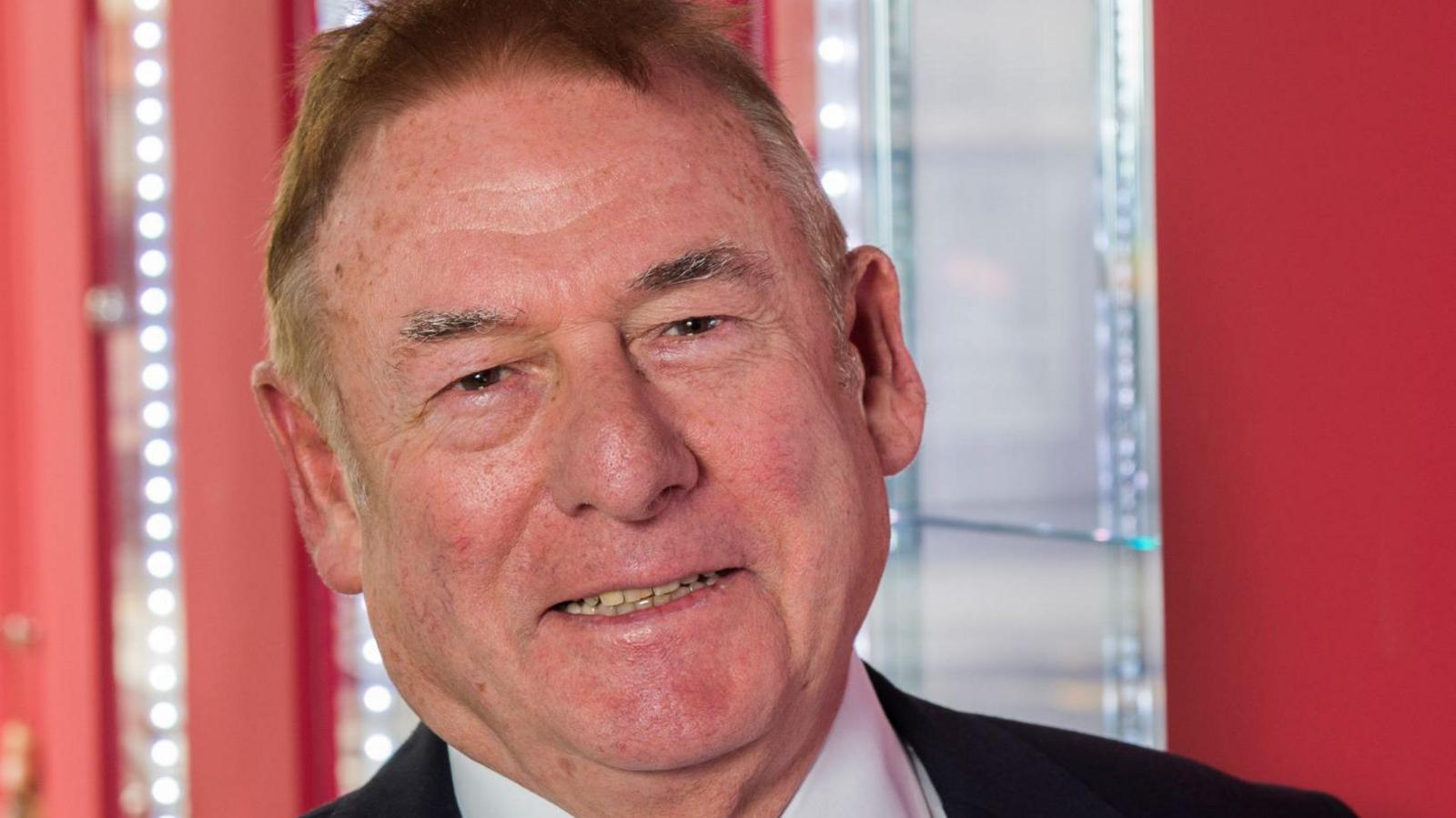 Bill Munro, dressed in a suit with tie, smiling at the camera