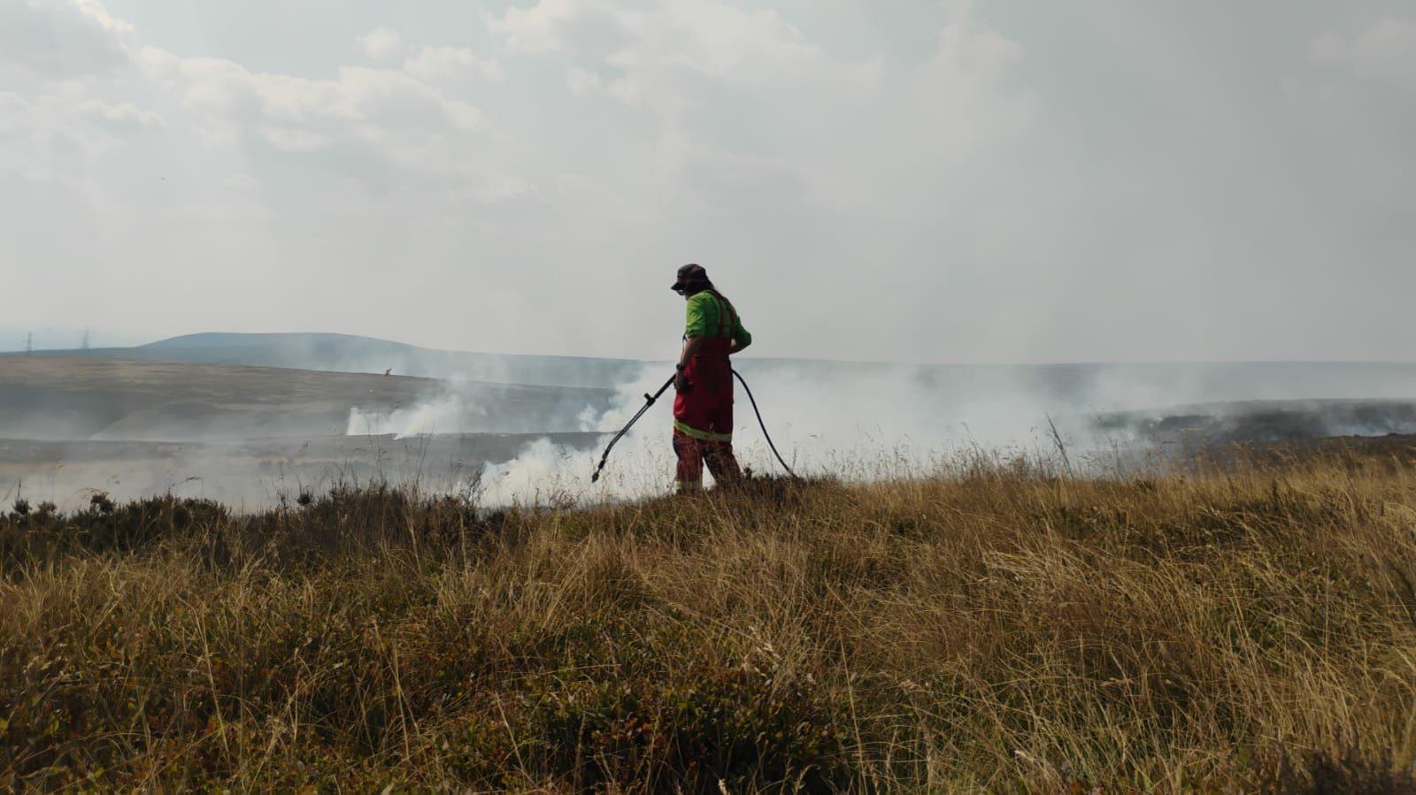 A silhouette of a person spraying a hotspot on the moors