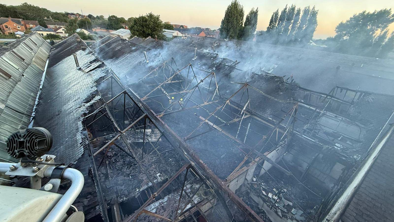 A large warehouse roof damaged by fire - seen from above