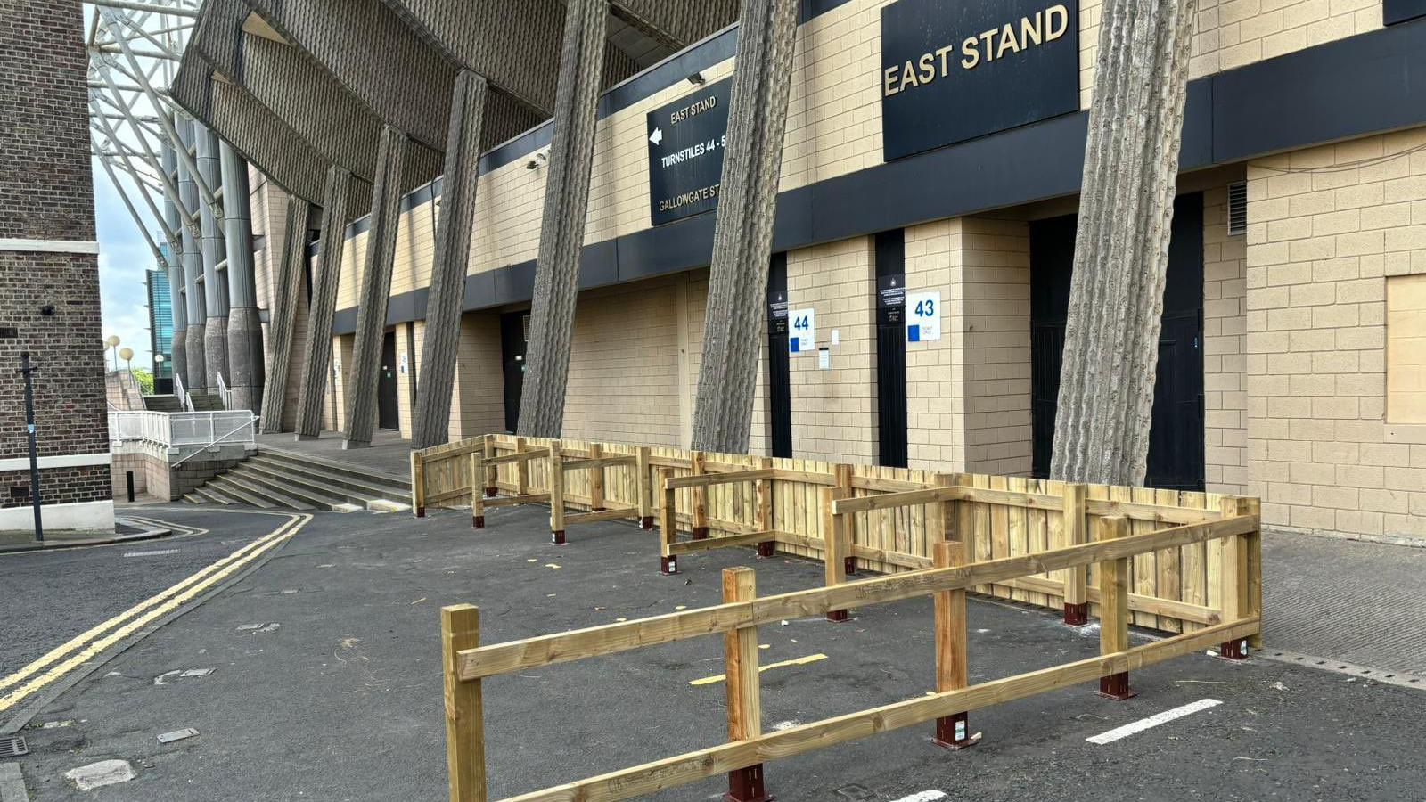 A wooden fence which has been erected around three parking spaces outside St James' Park. The fencing faces the entrance to the East Stand of the stadium.