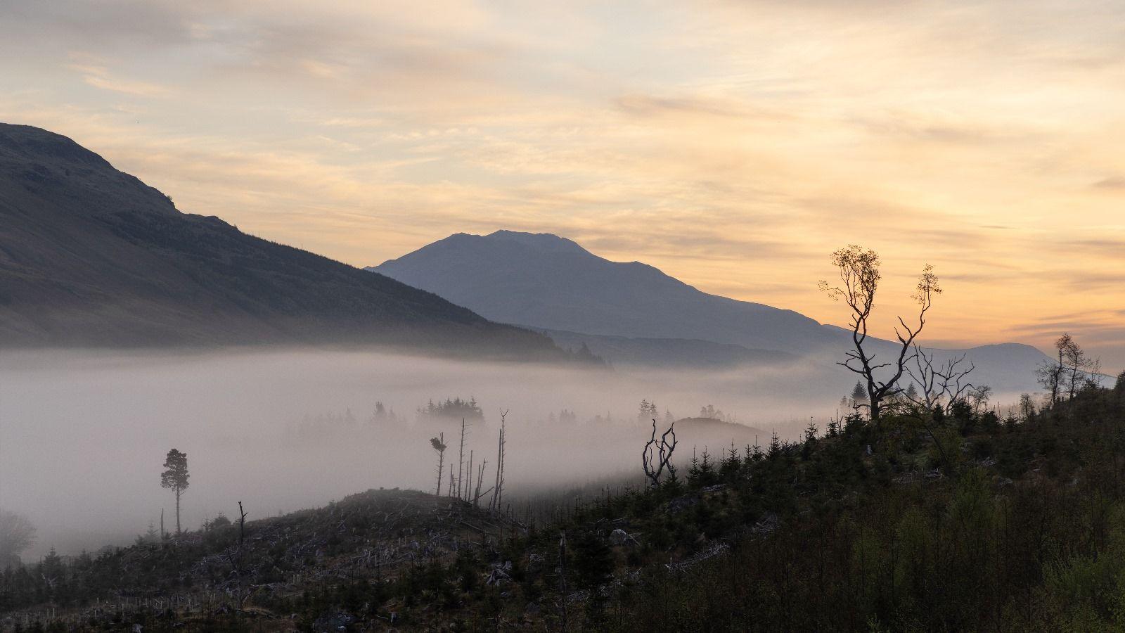 Two mountain peaks with a misty valley