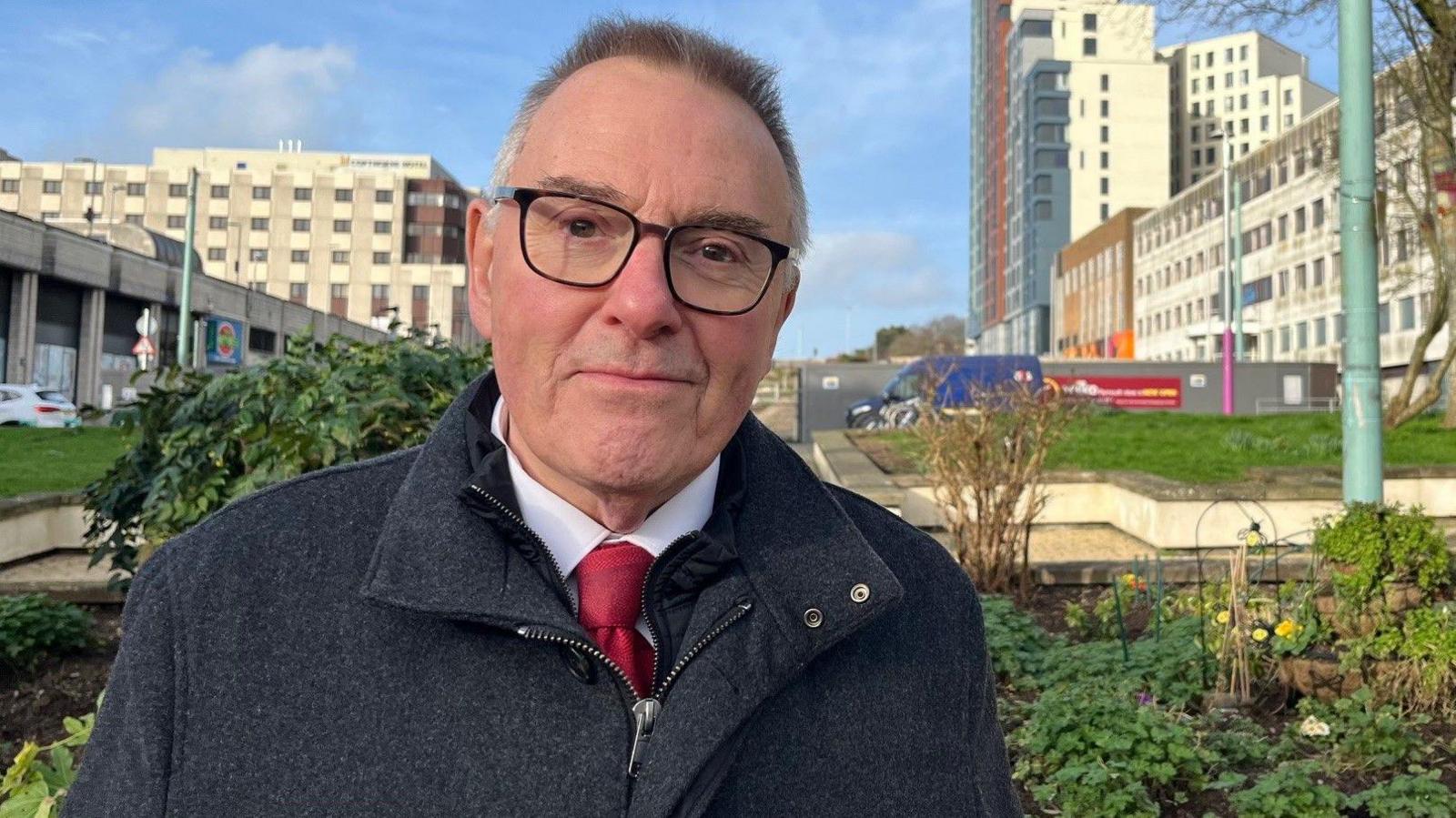 Plymouth City Council leader Tudor Evans in a shirt and tie and jacket in Armada Way, Plymouth