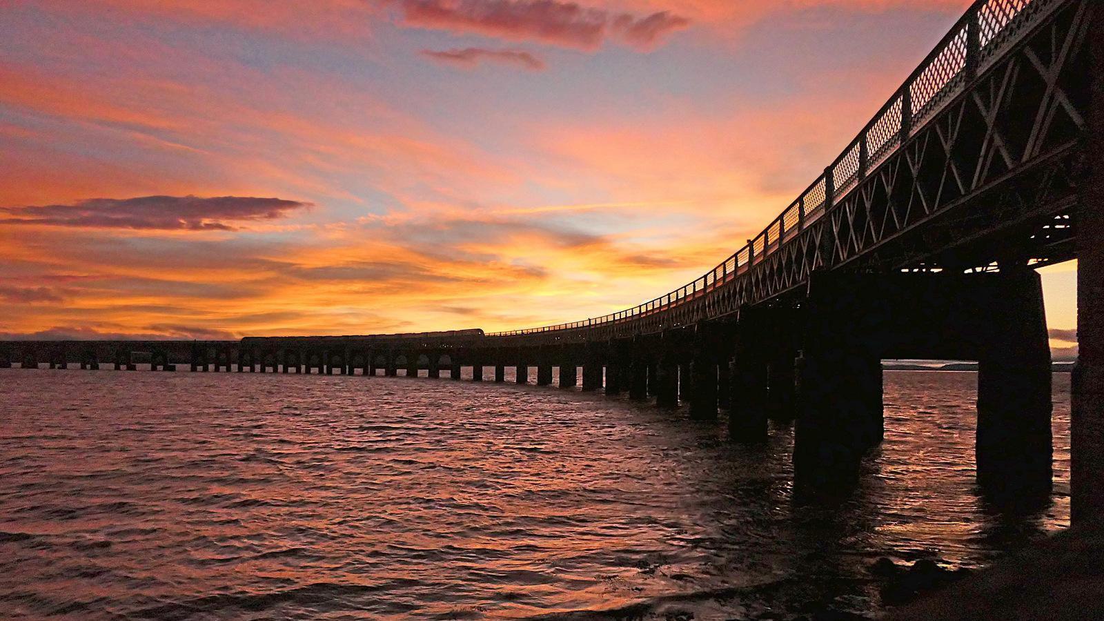 A large pier with a sunset behind