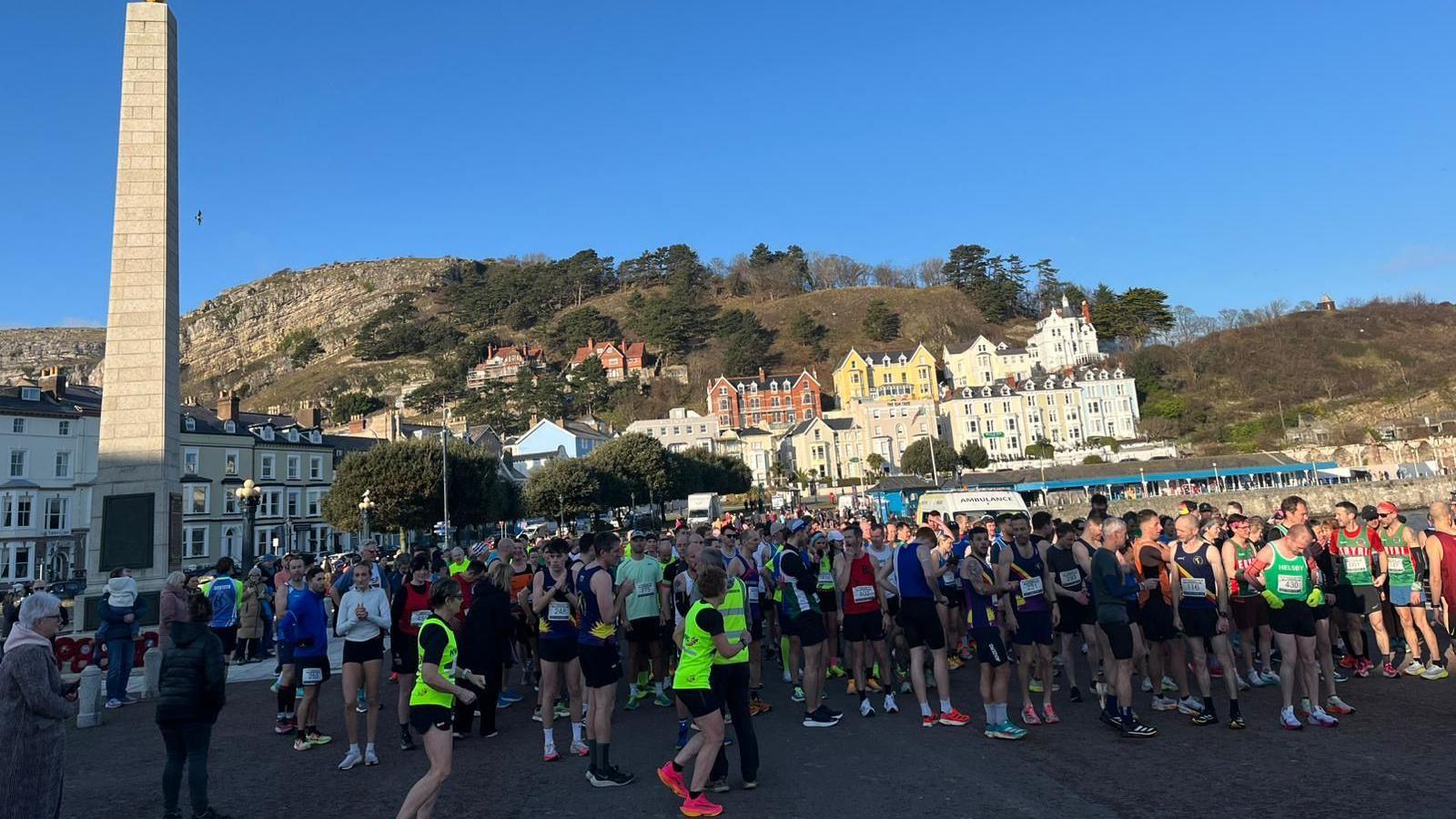 Hundreds of runners pictured in the sunshine in Colwyn Bay ready to begin the race. 