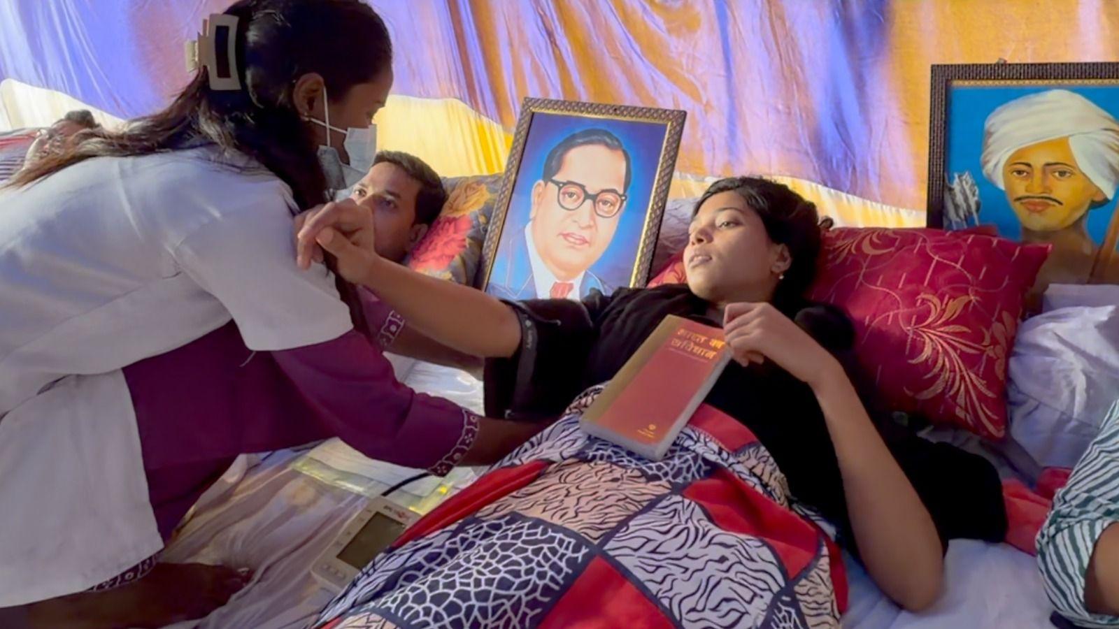 A doctor checks the vitals of Umme Habiba, one of the protesters in Ranchi who is on a hunger strike. She's laying on a mattress with a portrait of BR Amedkar kept to her left 