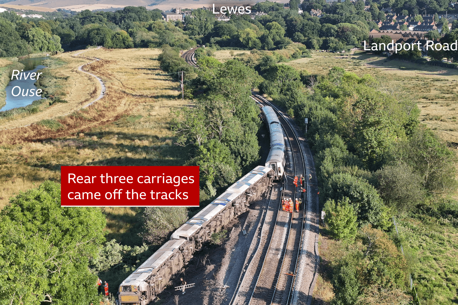 An aerial view of a derailed train on its side 
