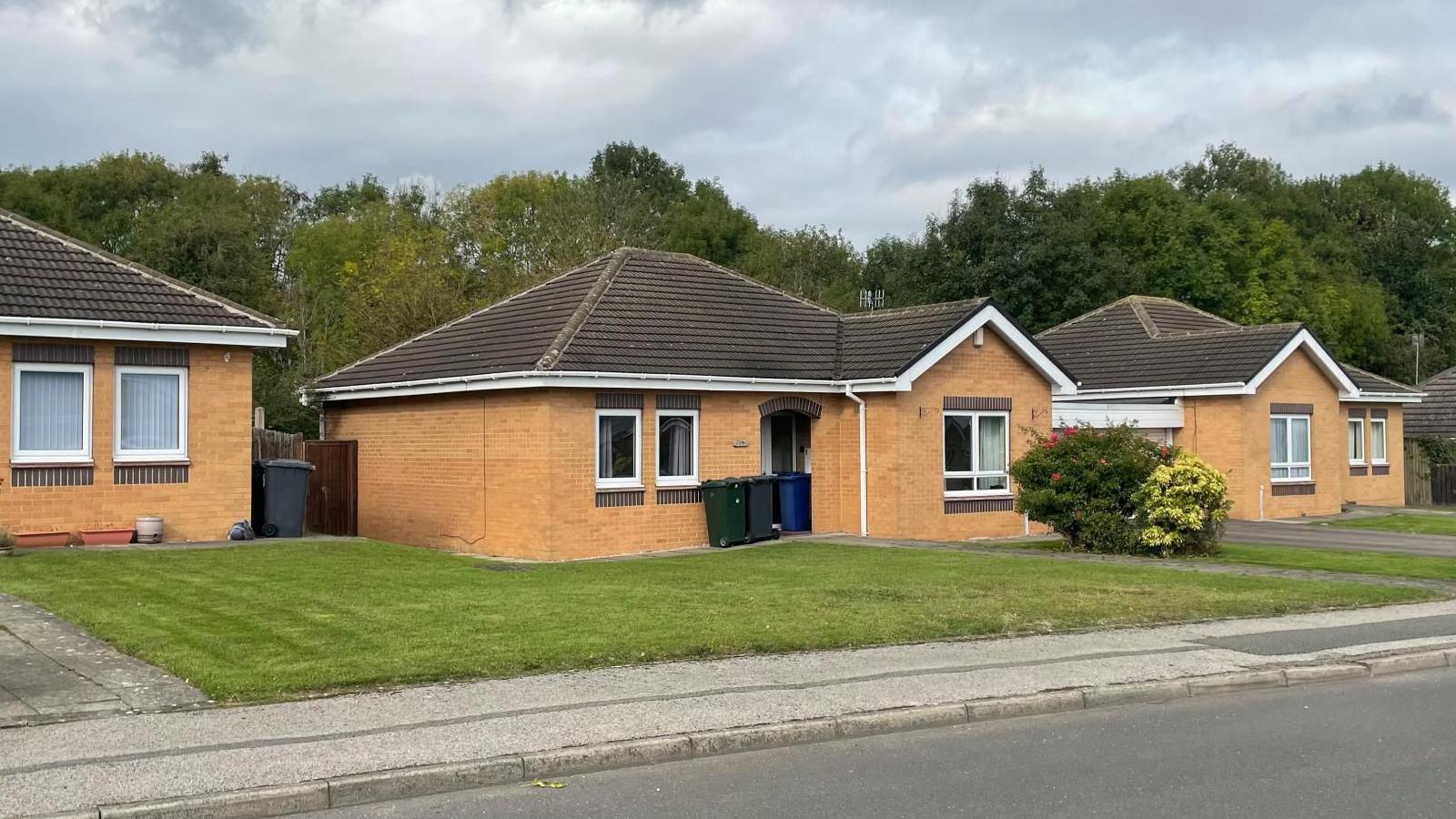 Three neat matching bungalows in a row with immaculate lawns