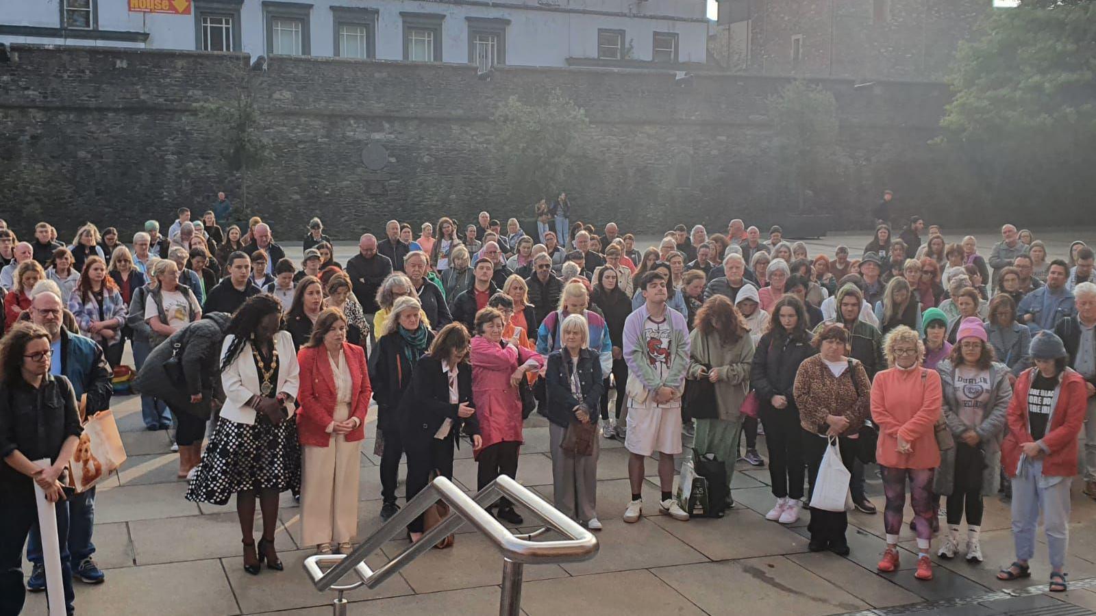 A crowd stands in Derry's guildhall sqaure during a vigil to two women who have been killed