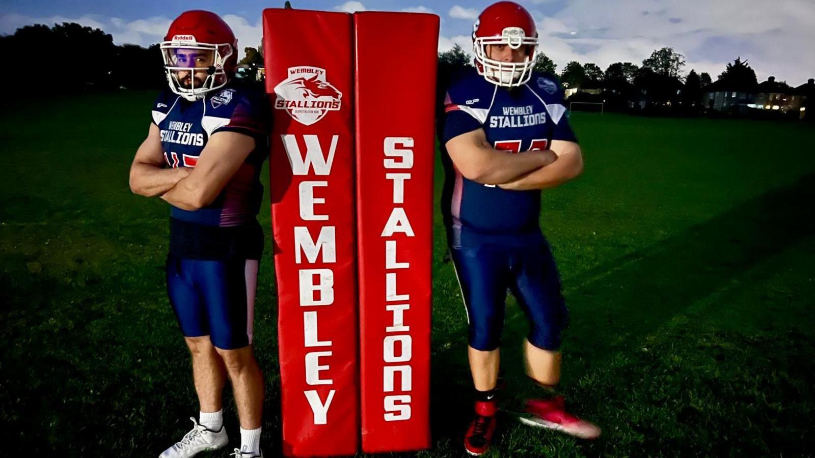 Two Wembley Stallions players standing either side of the goalpost pads