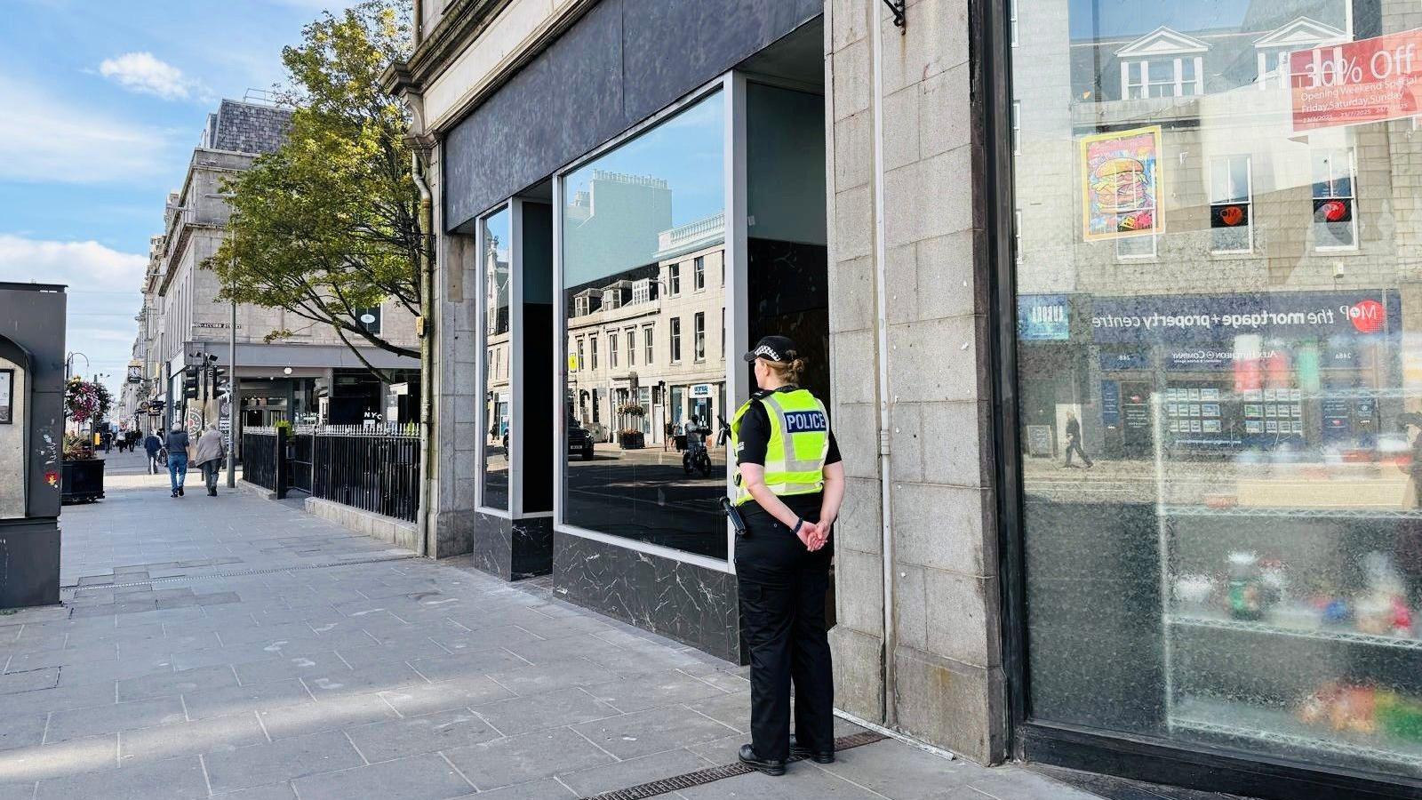 Police officer outside a building in Aberdeen's Union St
