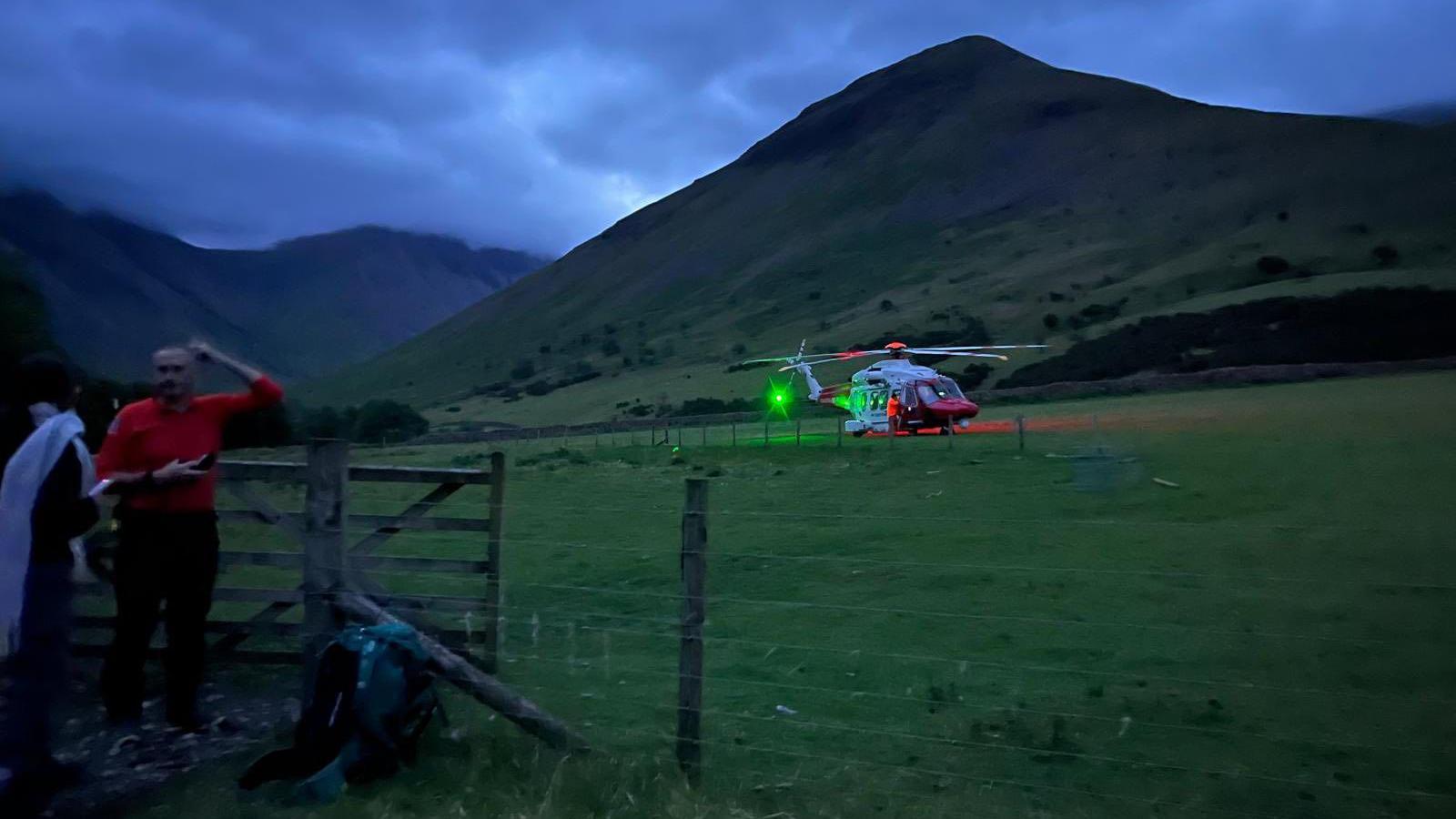 A rescue helicopter and Mountain Rescue team members assemble in the search of a missing young walker in the Scafell Pike area. 