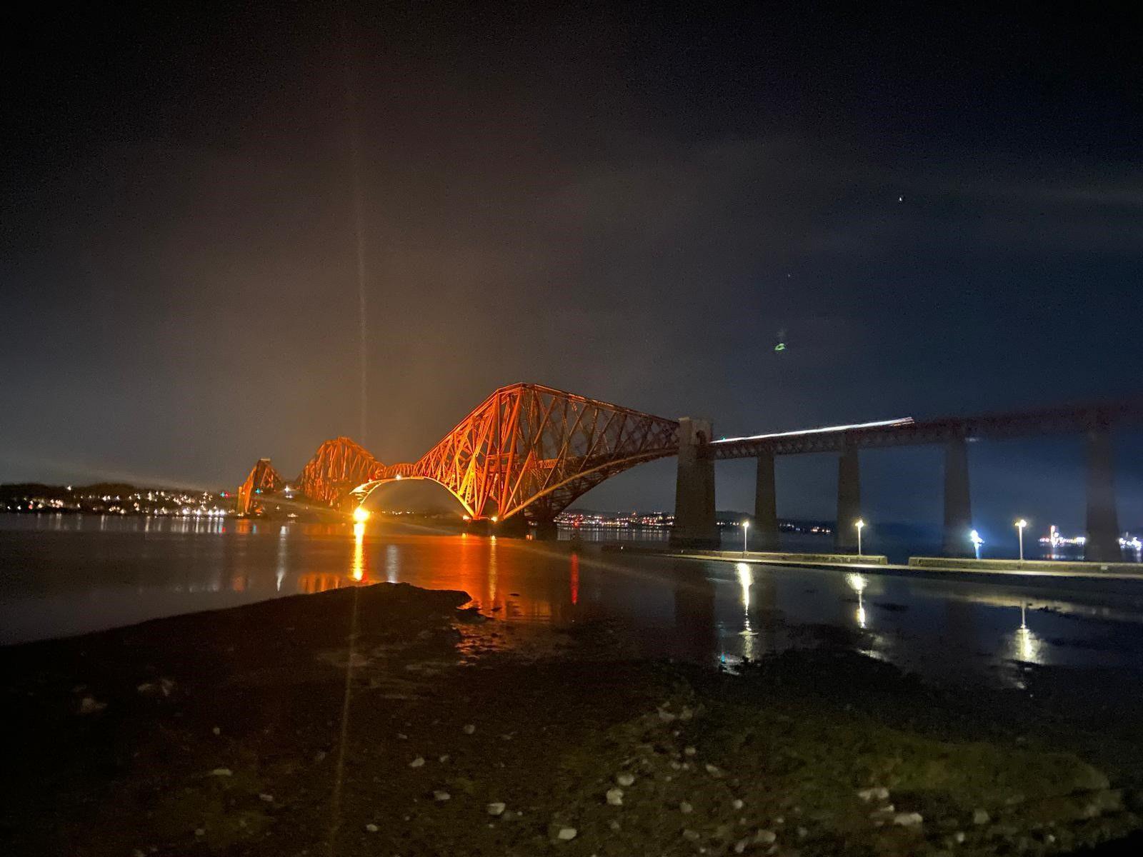 The red Forth Rail Bridge lit up at night