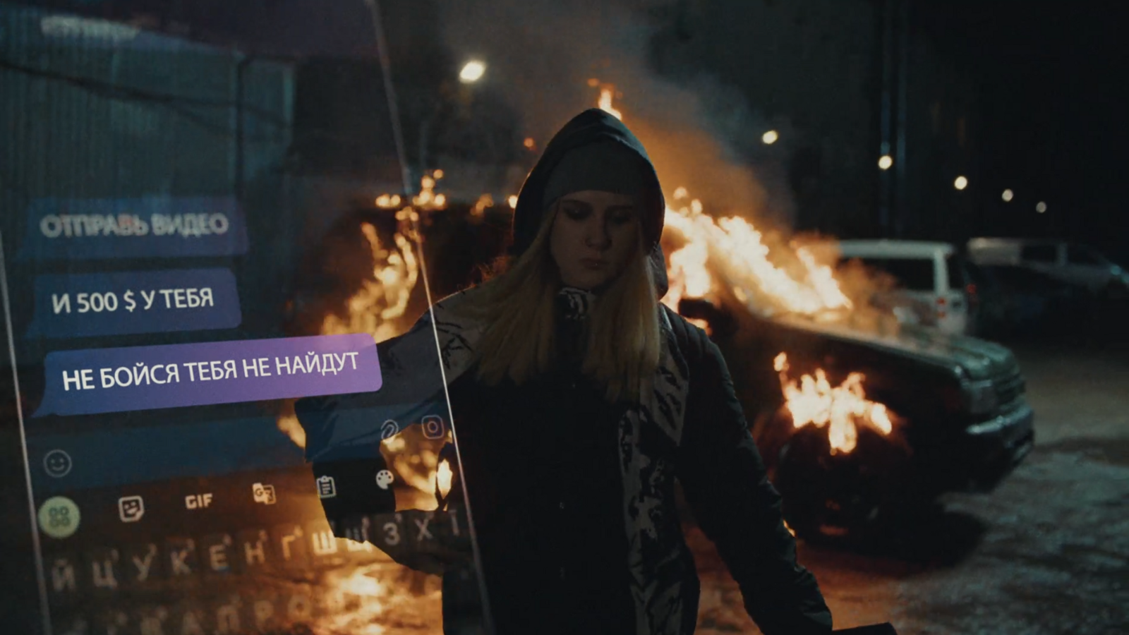 A still from an SBU video for a publicity campaign warning young people not to allow themselves to be recruited as saboteurs. The fictionalised image shows a hooded teenage girl walking from a van she has just set fire to at night. In the left of the screen is an untranslated image of the girl's phone messaging exchanges with the person who has ordered her to carry out the attack.