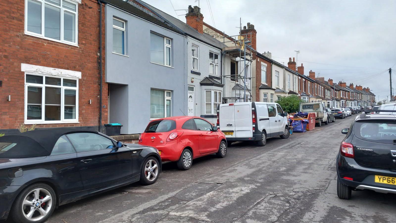 A street with terraced houses and cars