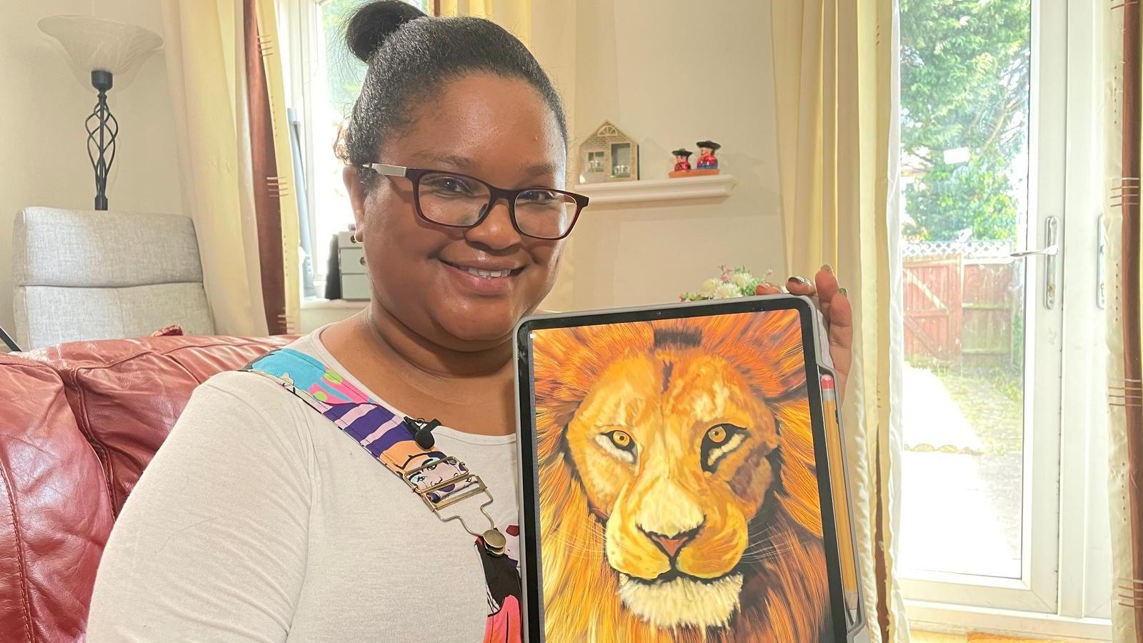 Bethany holding a drawing of a lion she made on a tablet