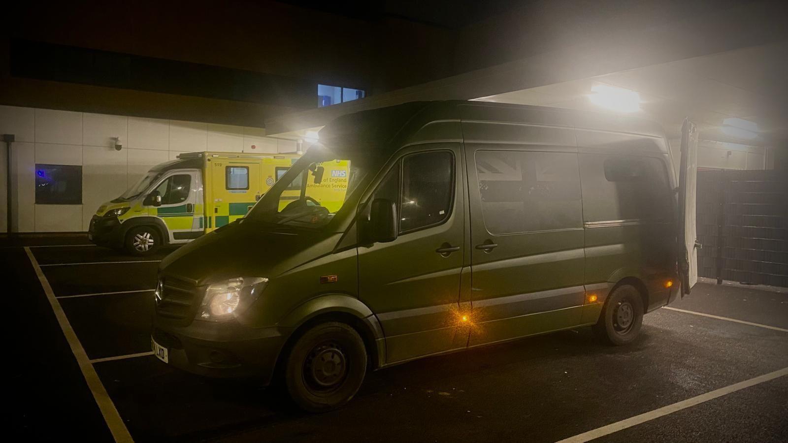 Steve's van parked in the Ipswich Hospital car park. An ambulance is parked next to it and it is dark outside.