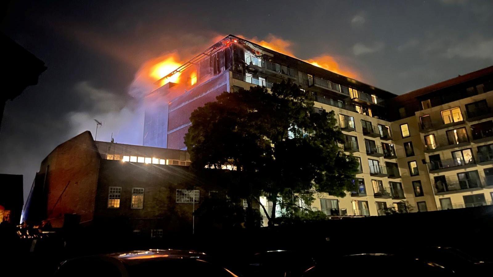The apartment when the fire occurred last year with a blaze of fire on the top. 