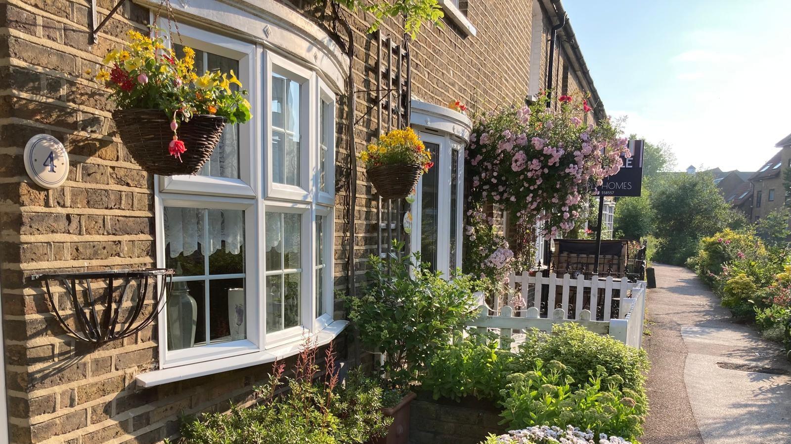 A row of terraced houses with small gardens and picturesque gardens