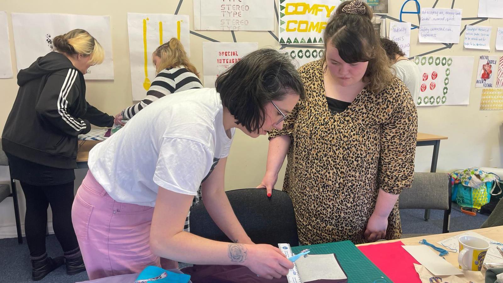 Emily Andrews assists Alice with her textile skills