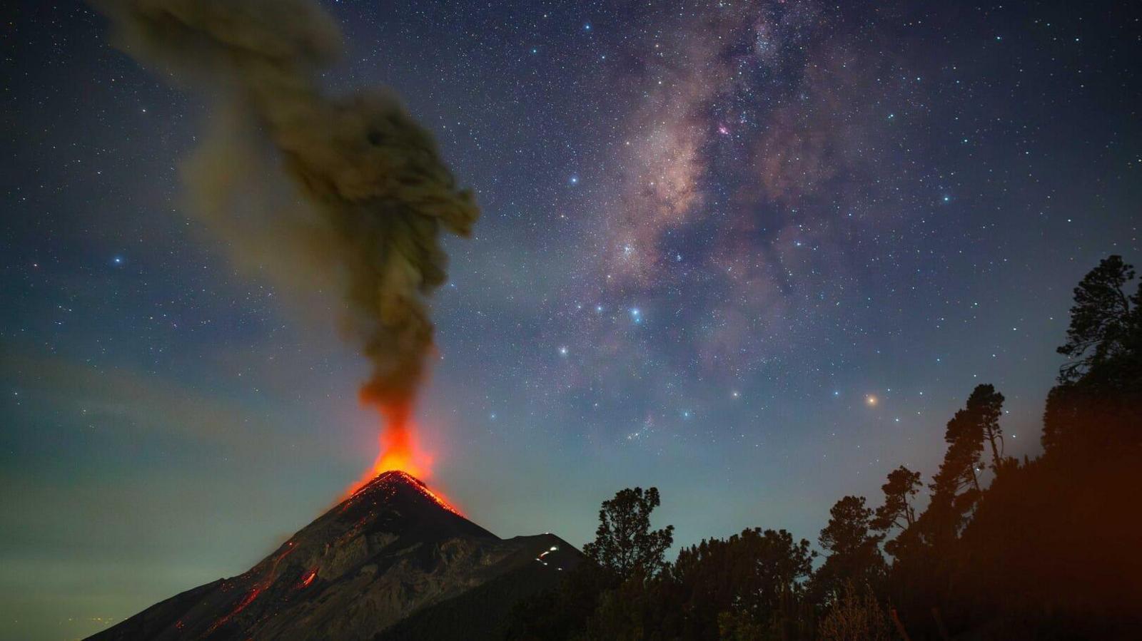 Volcan de Fuego erupting with the Milky Way galaxy visible above it.