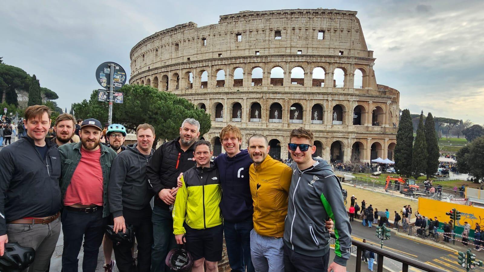 Ian and the group taking a photo together in Rome. The famous Colosseum can be seen in the background