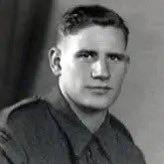 Black and white photograph of a man in a wartime military uniform. He is looking at the camera. 