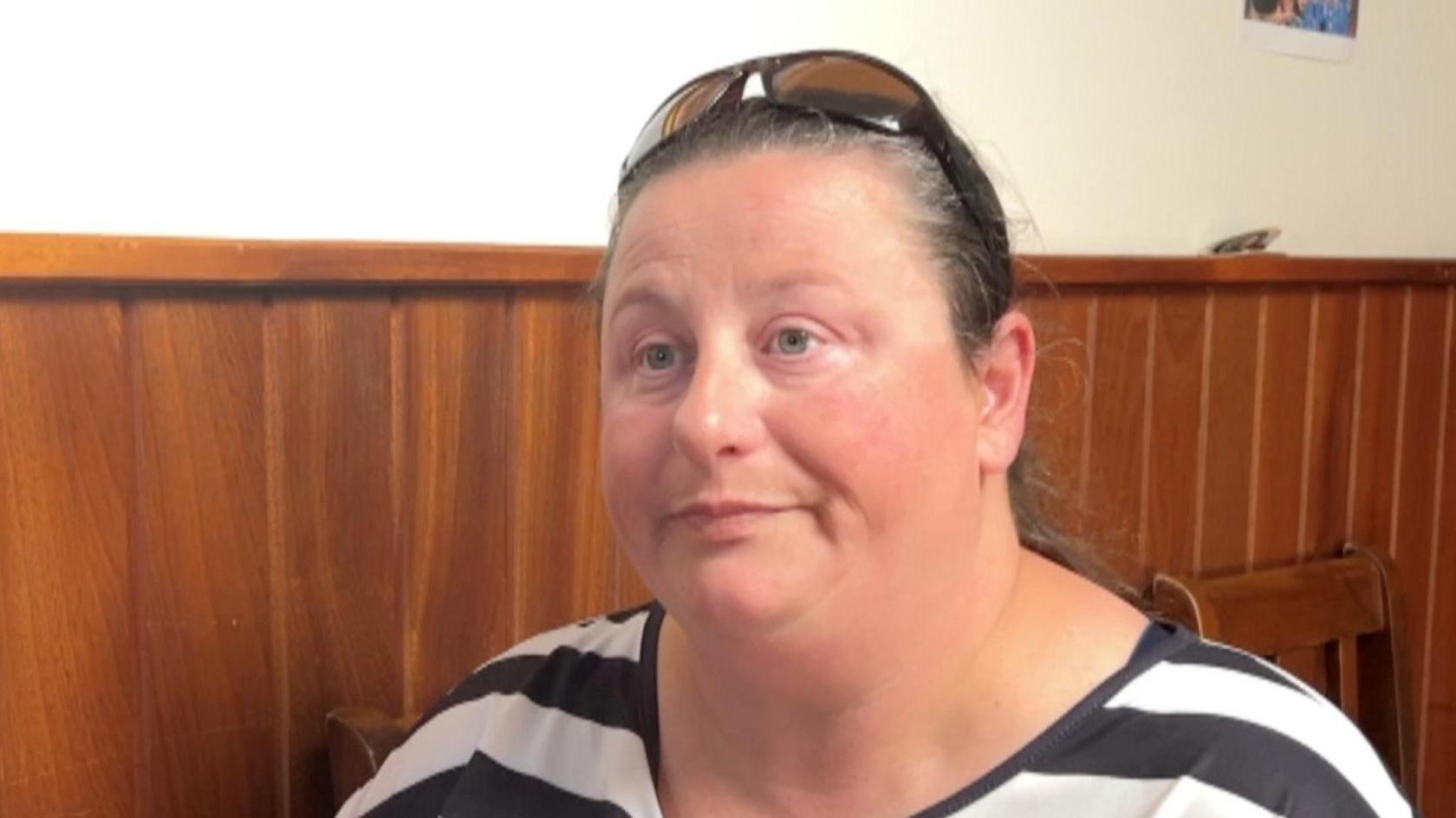 lady with stripy t shirt and sunglasses on head 