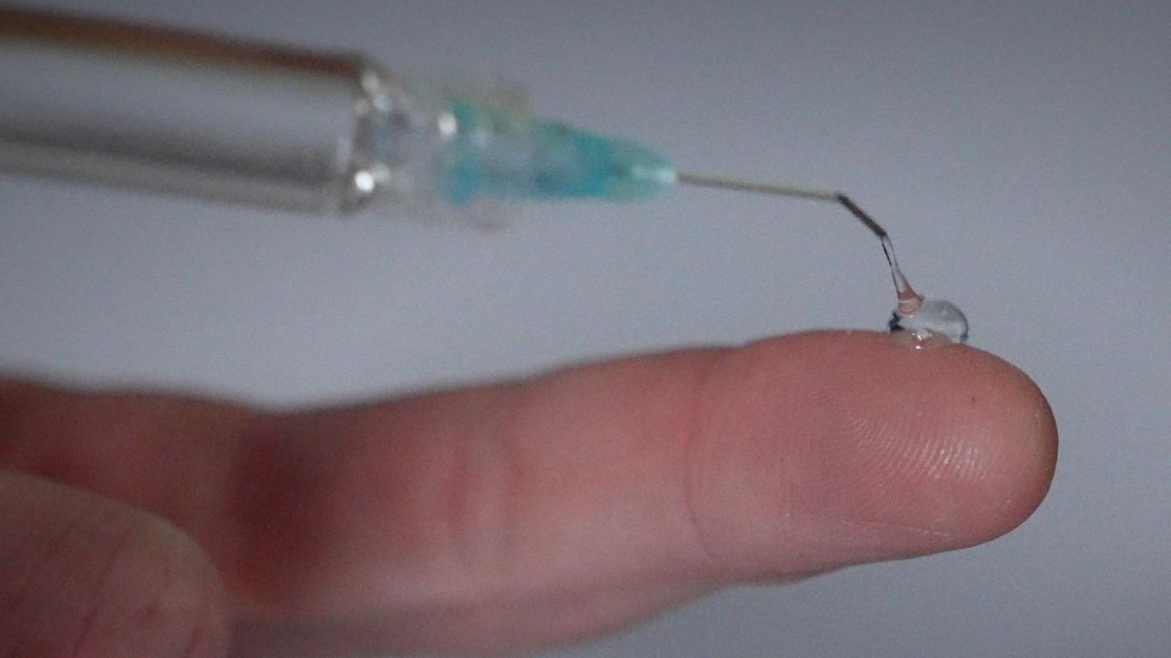 A blob of the clear gel on a fingertip, showing its viscosity and transparency.