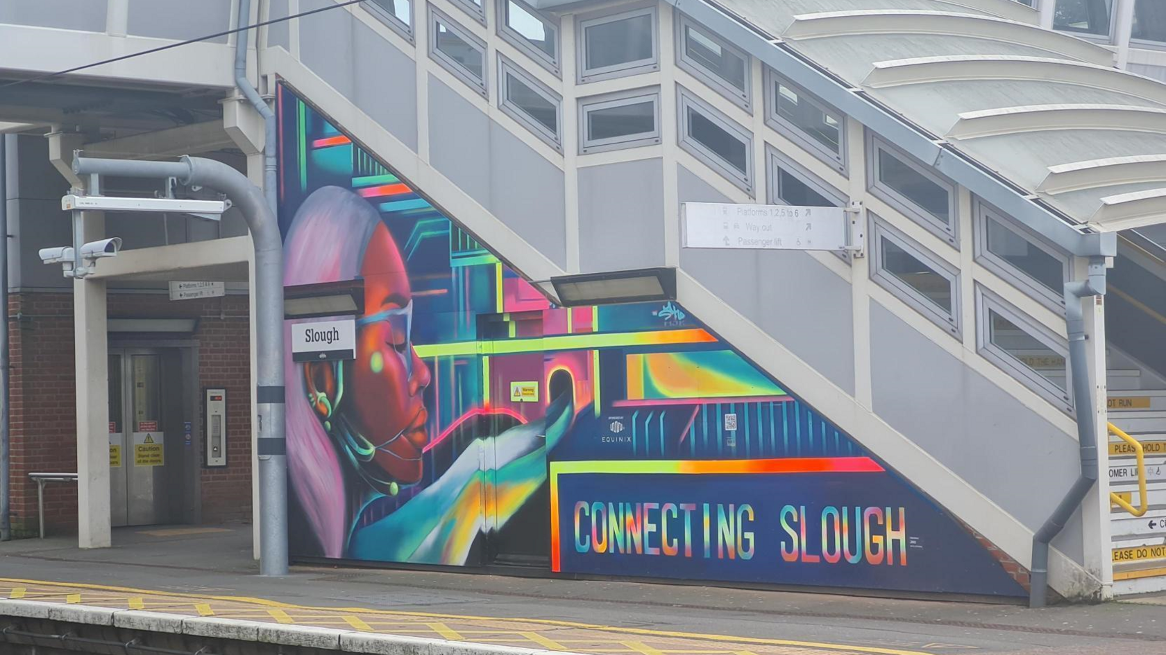A mural of a girl in multiple colours. Next to her are the words "Connecting Slough".