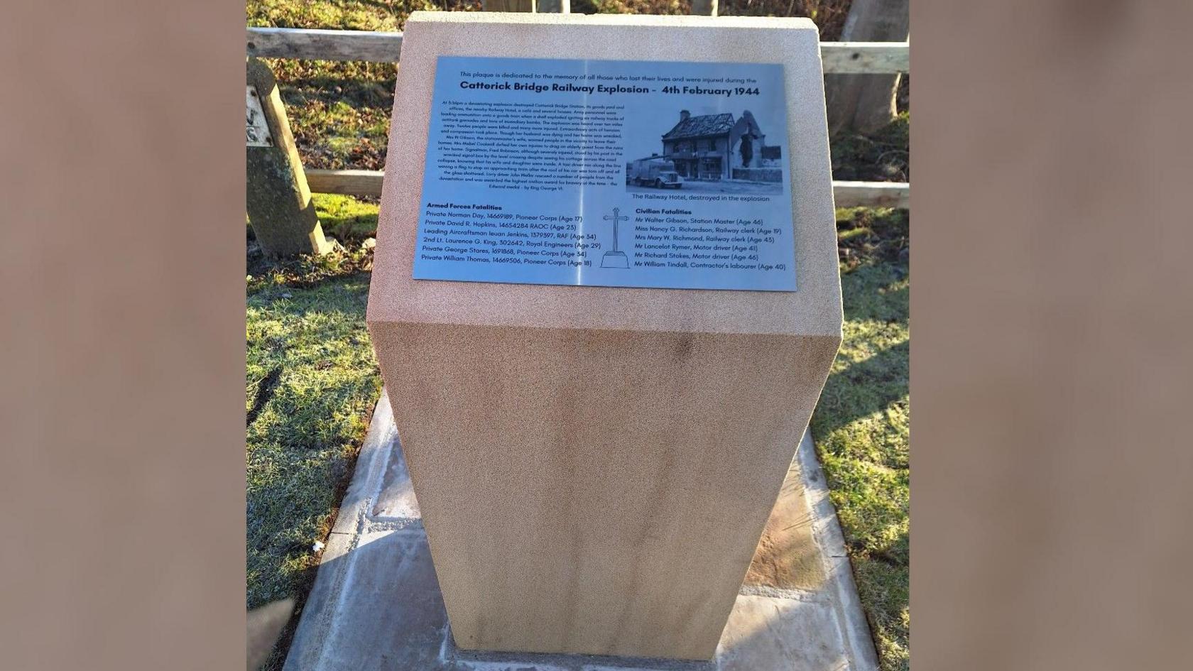 A stone plinth with a plaque on top with some written history of a munitions WW2 disaster and the names of the 12 victims who died from the explosion. 