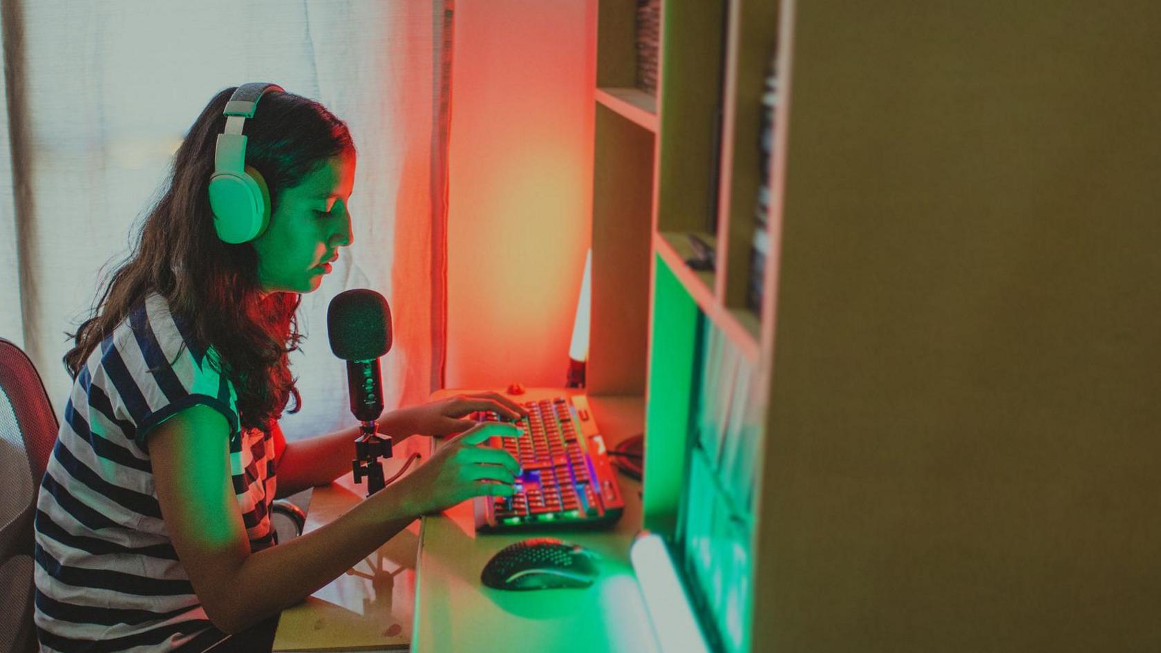 A Teenage Girl in Headset and Microphone at Her Desk 