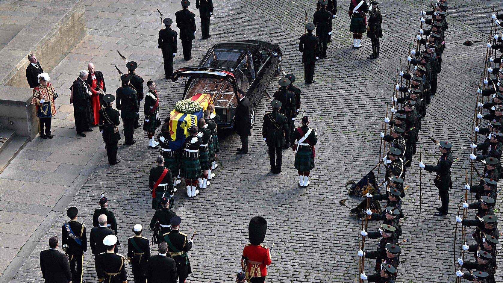 Pallbearers prepare to carry the coffin of Queen Elizabeth II, draped in the Royal Standard of Scotland, into St Giles' Cathedral