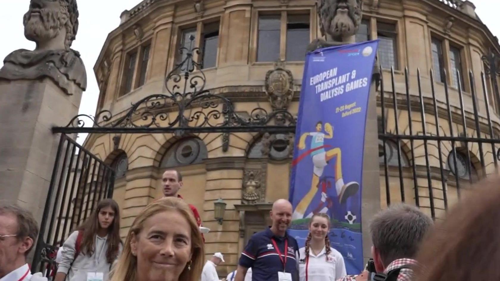 The Sheldonian Theatre with various people exiting through the front gate. Hung from it is a sign saying 'European Transplant and Dialysis Games.