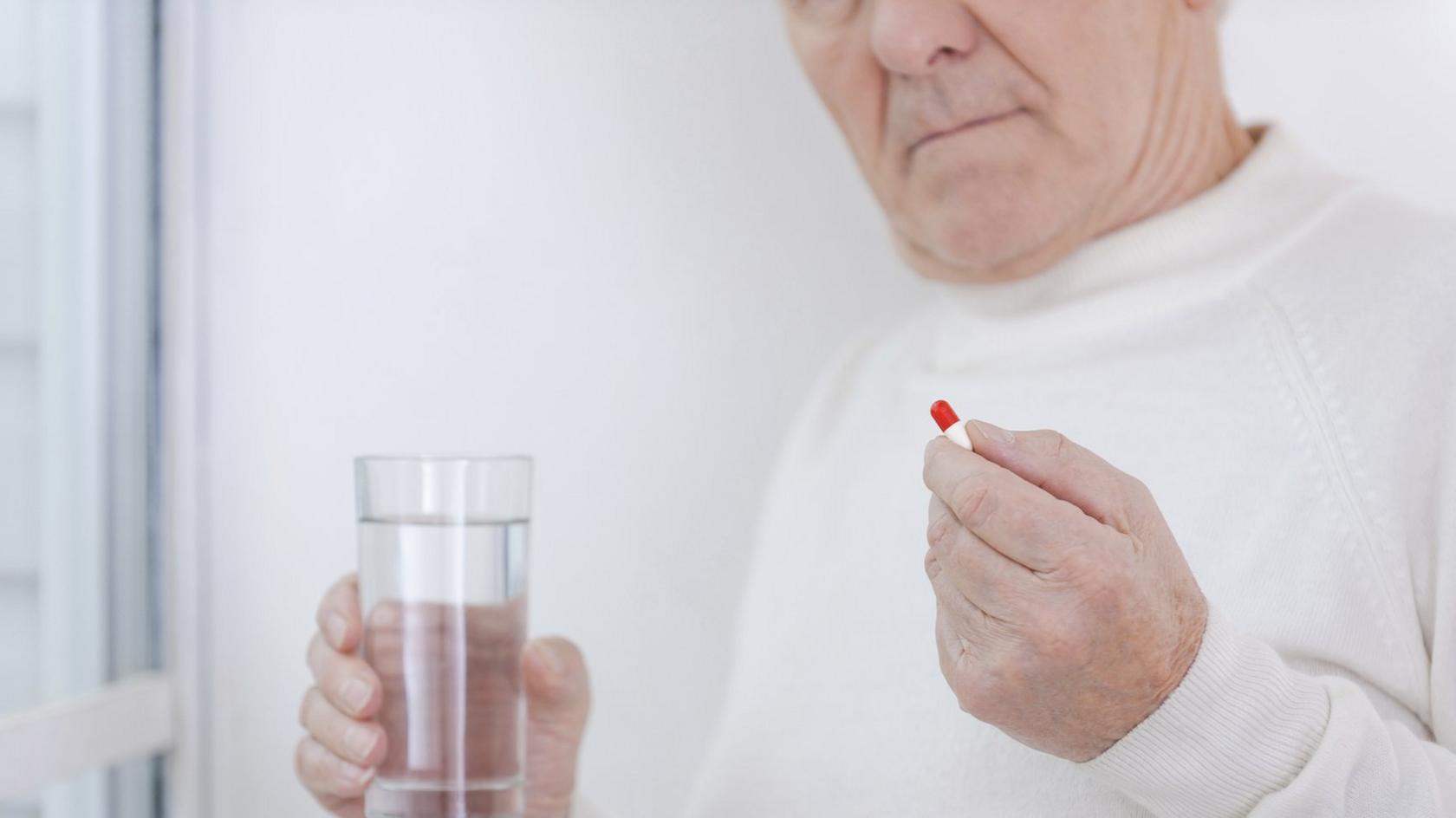 Elderly man taking pill