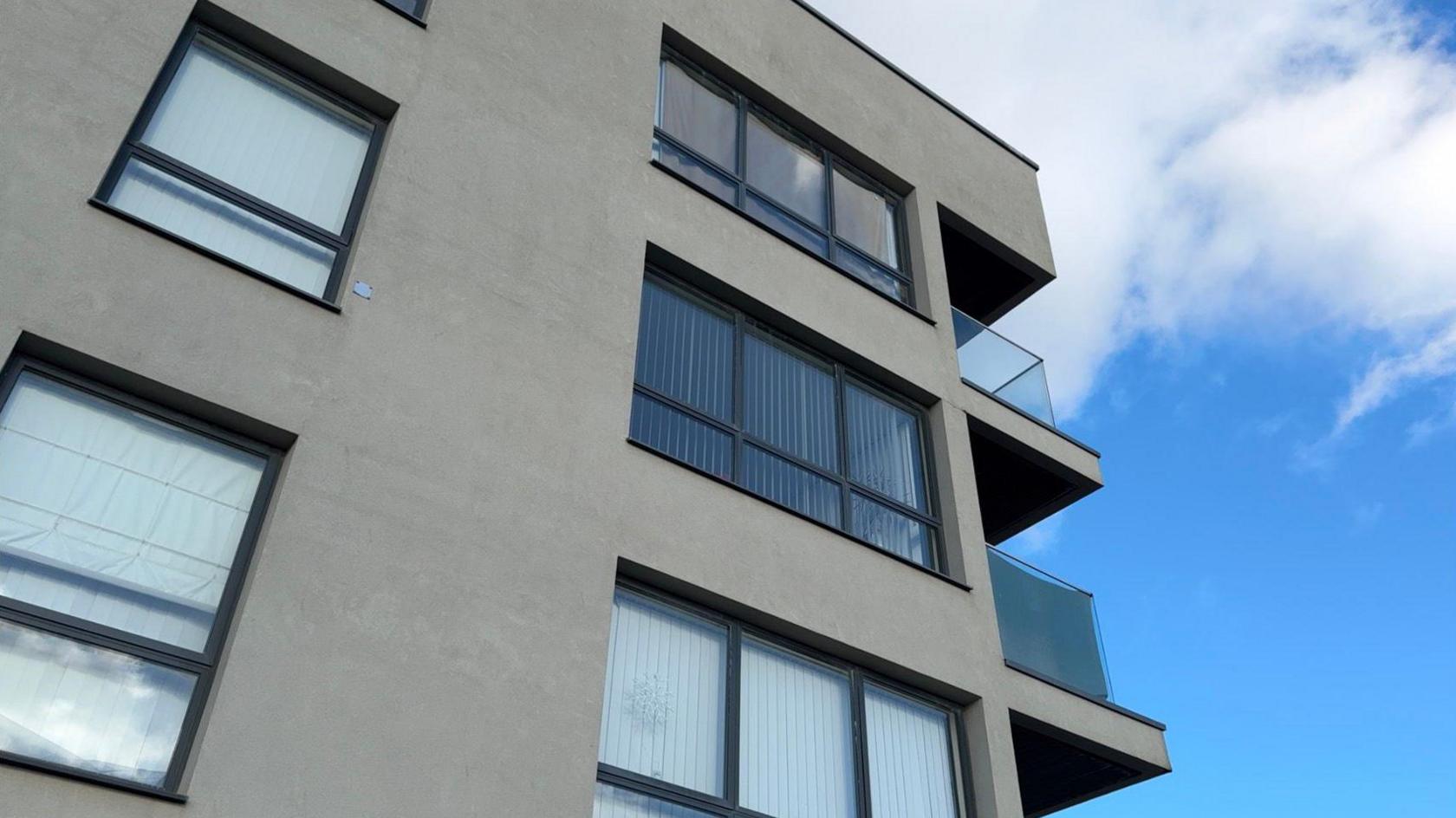 A grey, modular building with glass windows