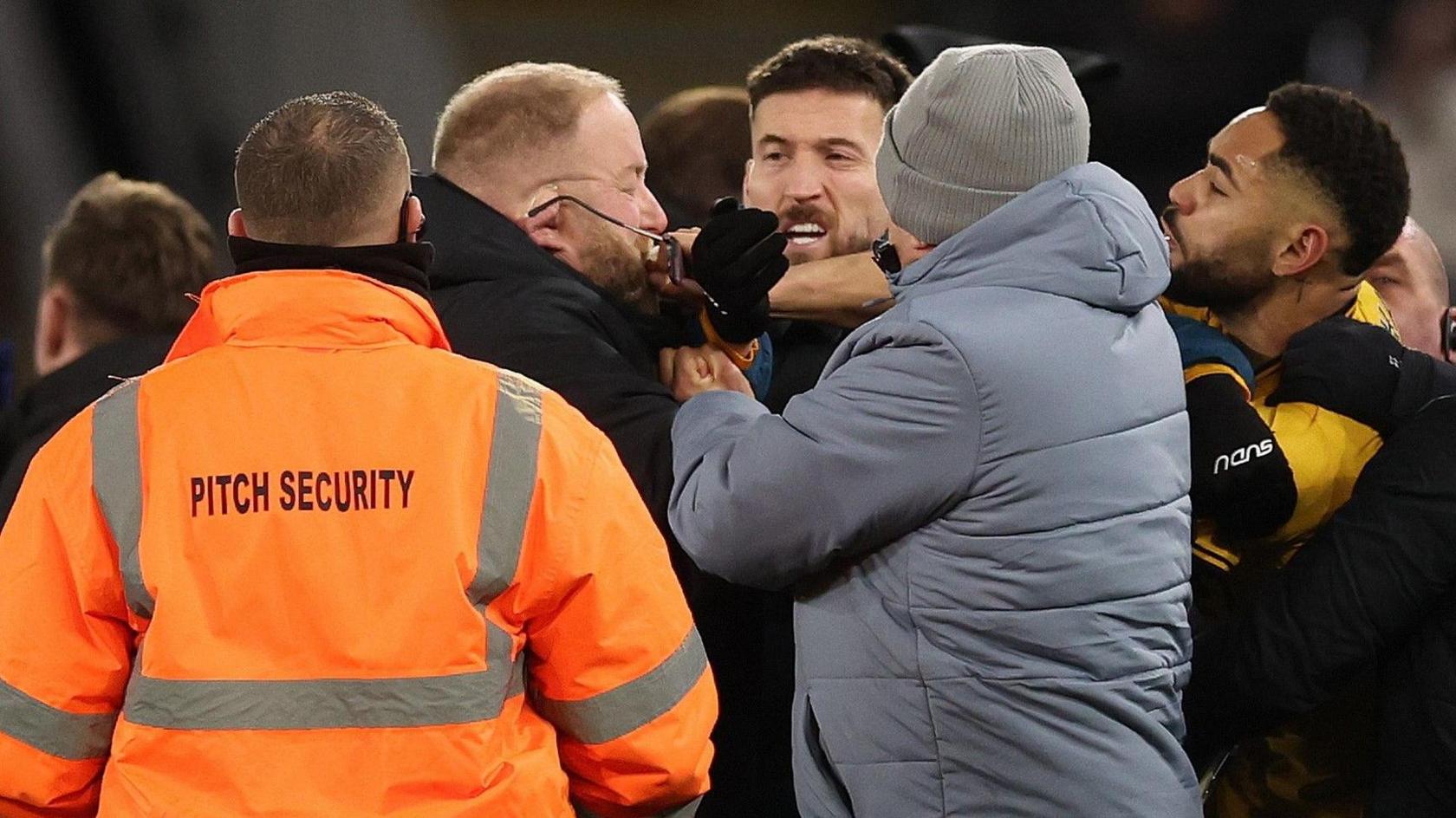 Matheus Cunha scuffles with Ipswich's security on the pitch at Molineux.