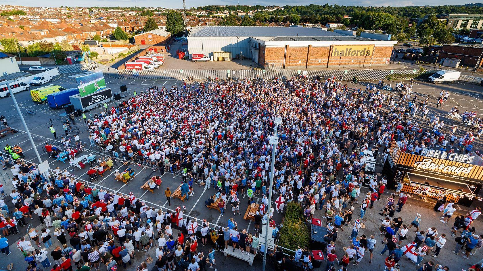 Thousands of fans watch England play Spain on an outdoor screen at Ashton Gate Stadium. They are photographed from above by a drone