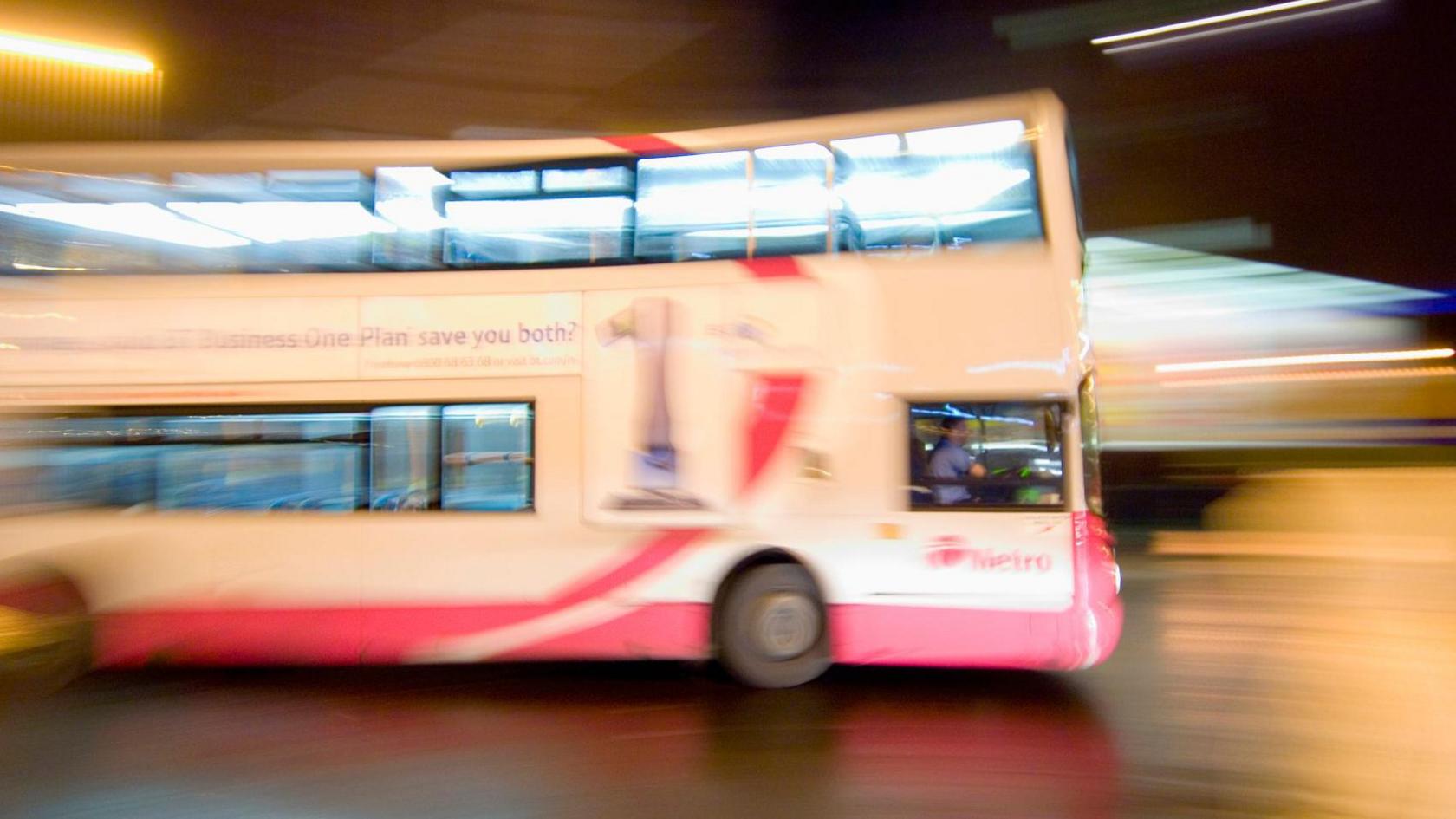 A bus in side profile, in a blurry field of vision suggesting movement.