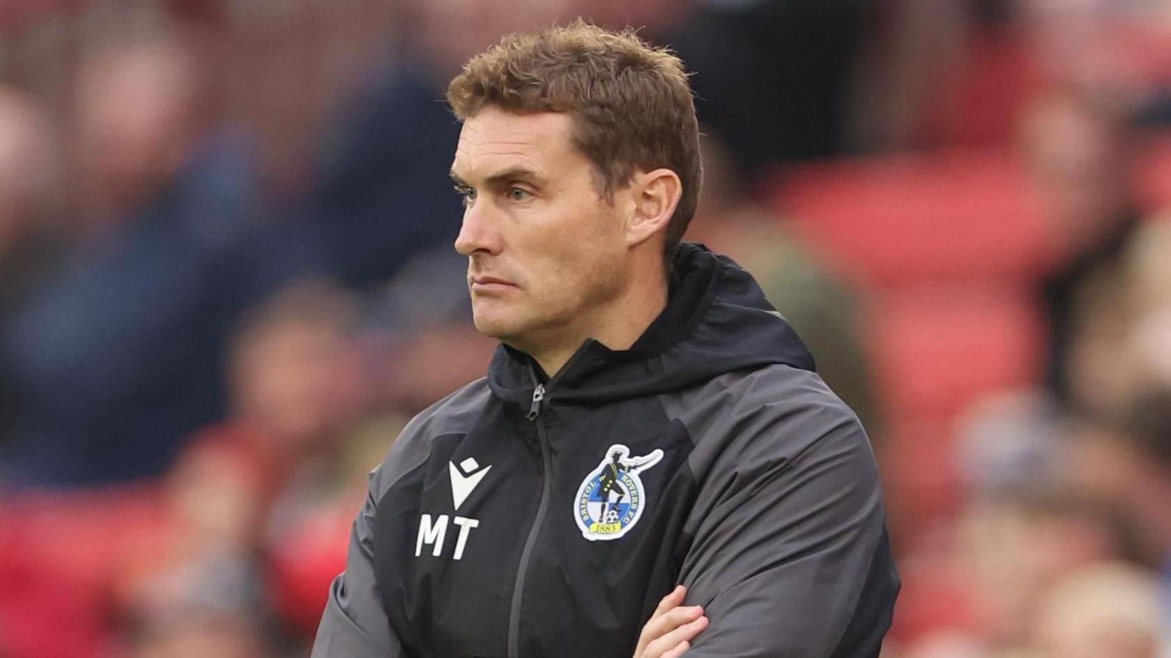 Matt Taylor on the touchline wearing a Bristol Rovers tracksuit