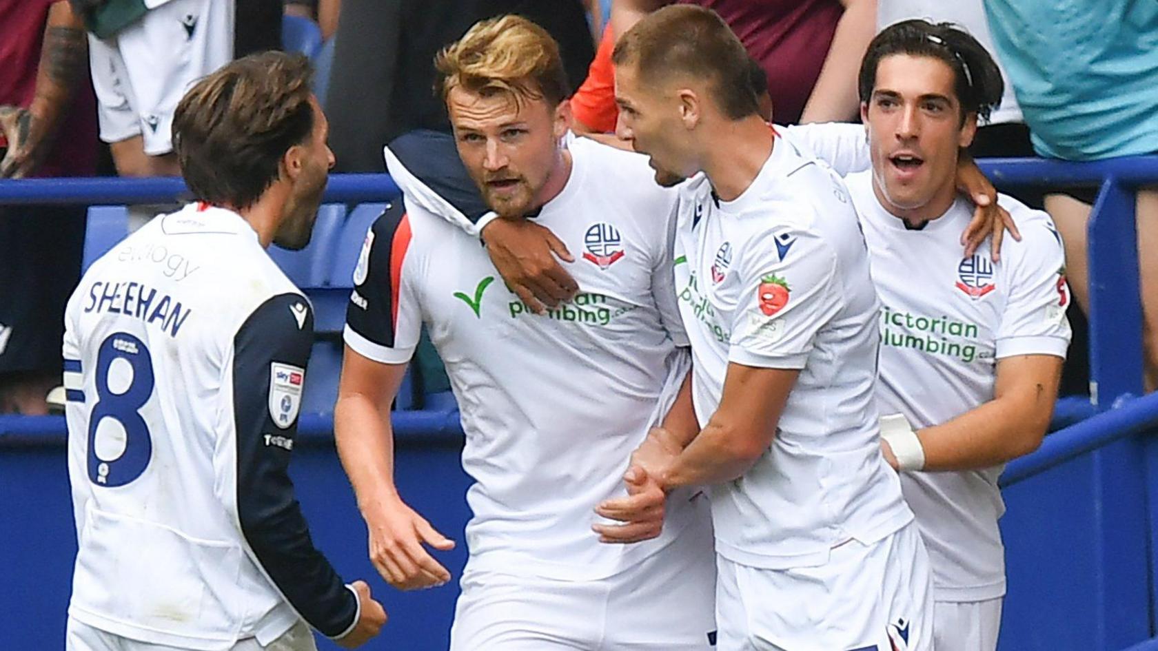 Bolton players, wearing their white home shirt, celebrate a goal against Preston