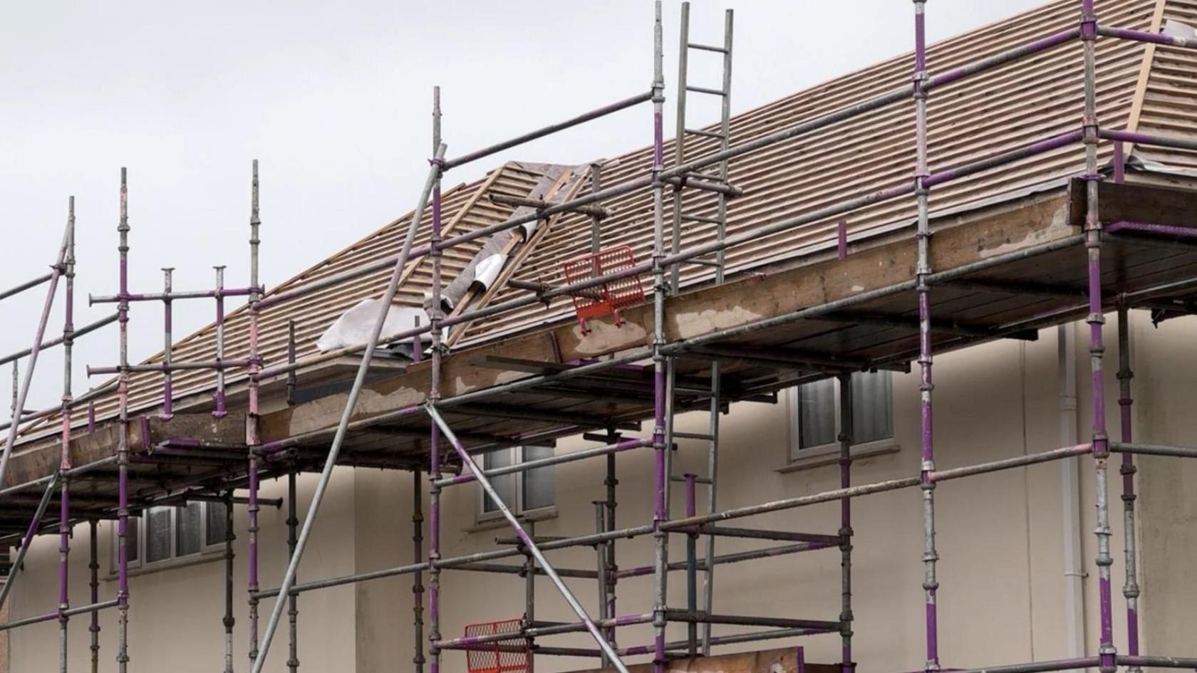 Scaffolding around the roofs of homes with no tiles