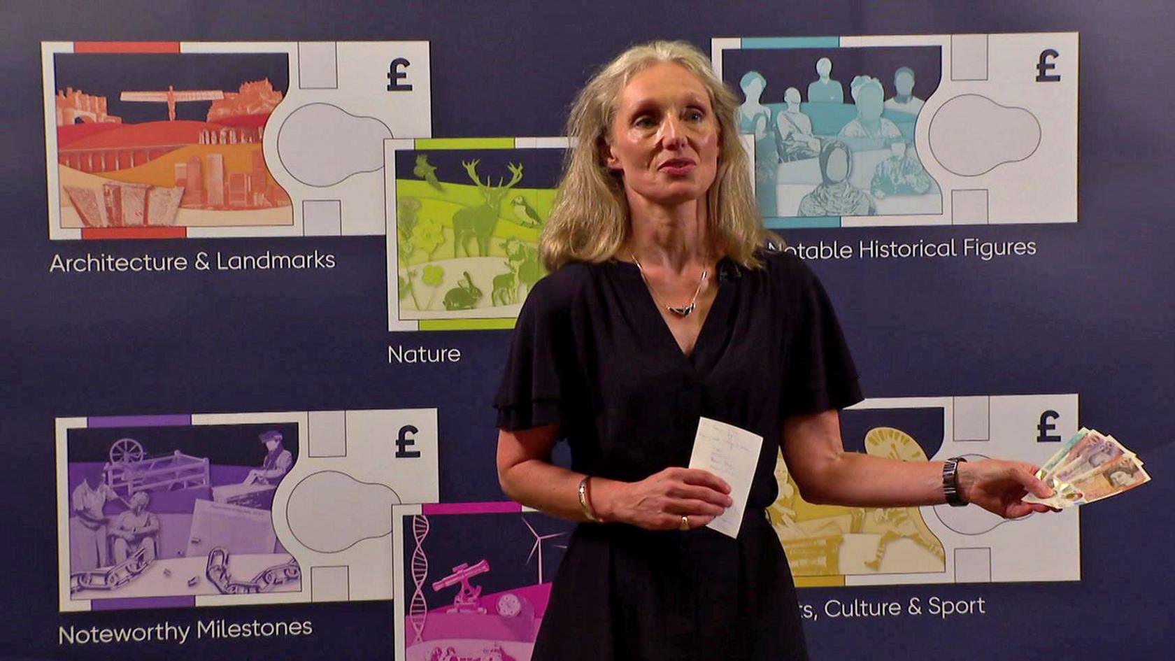 Bank of England chief cashier Victoria Cleland holds banknotes and stands in front of mock-ups of new themed notes.