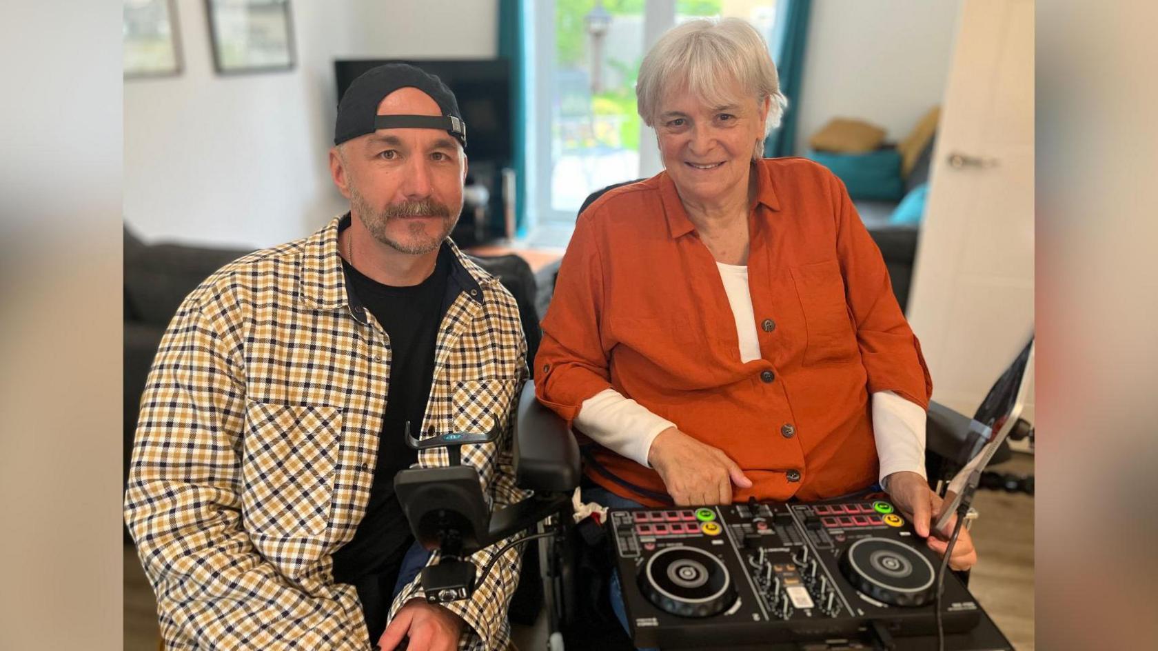 Paul and Sue, with DJ decks on Sue's lap
