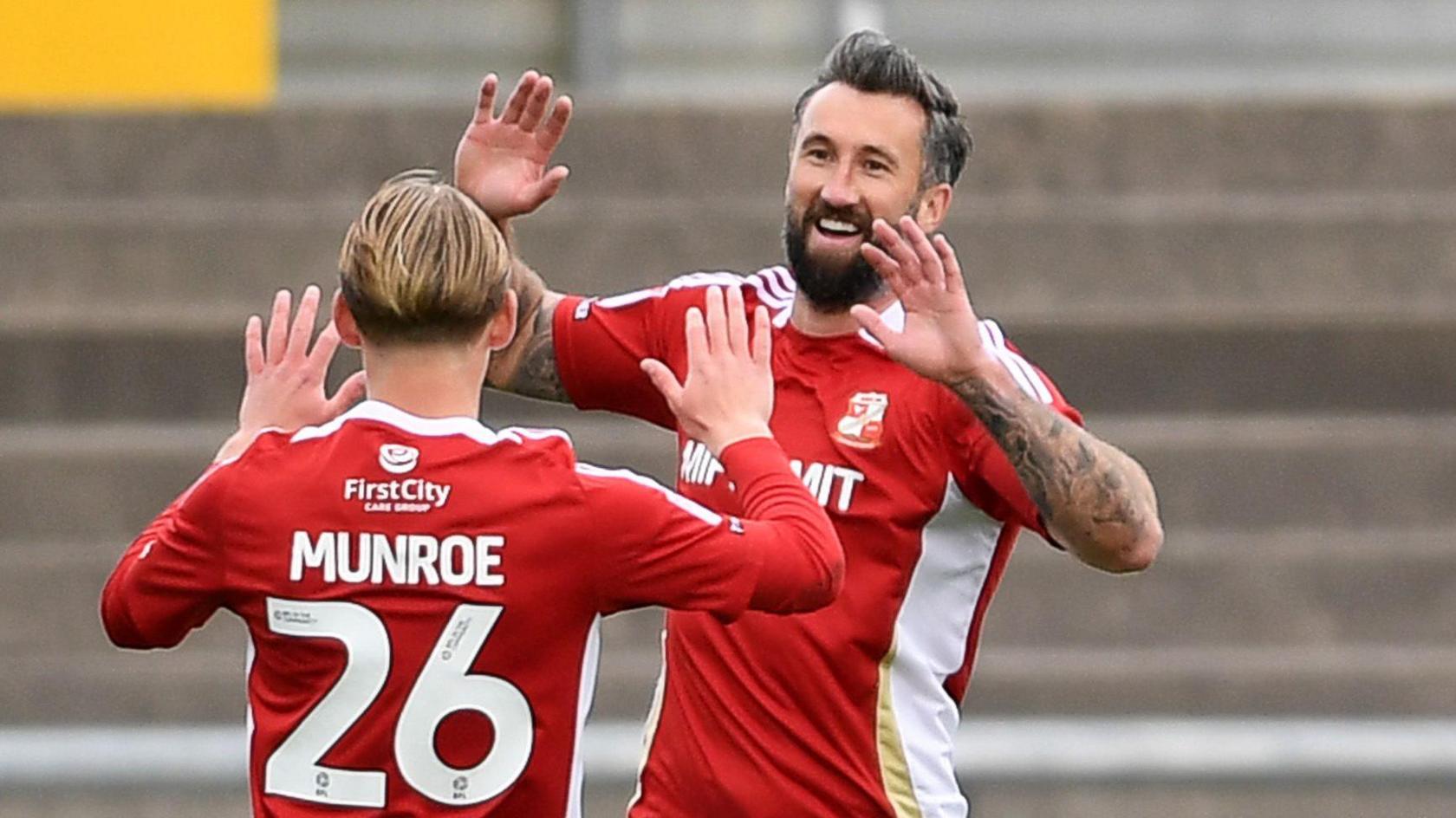 Ollie Palmer celebrates with Finley Munroe after putting Swindon in front at Newport County