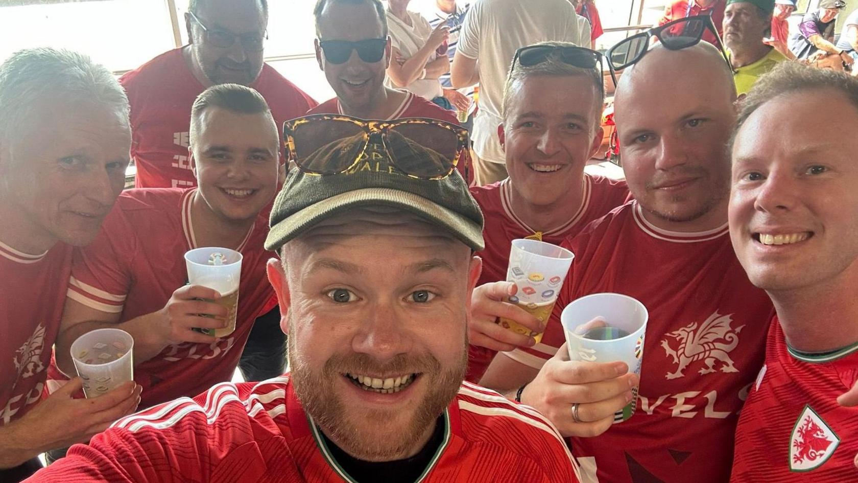 Aaron Hill and Matt Jones in their football shirts with six other German fans who are wearing homemade Welsh shirts