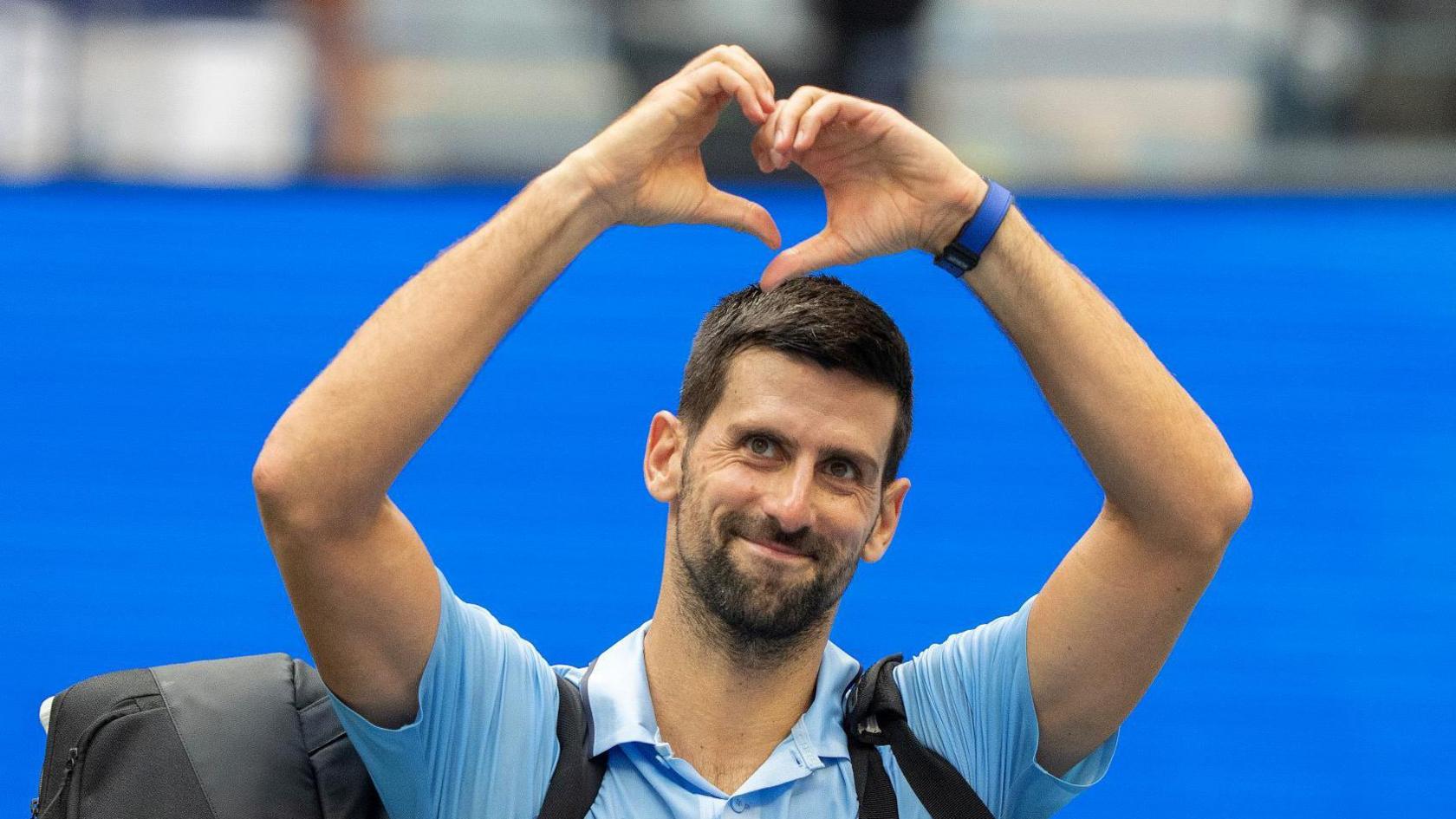 Novak Djokovic makes a heart sign to the US Open crowd
