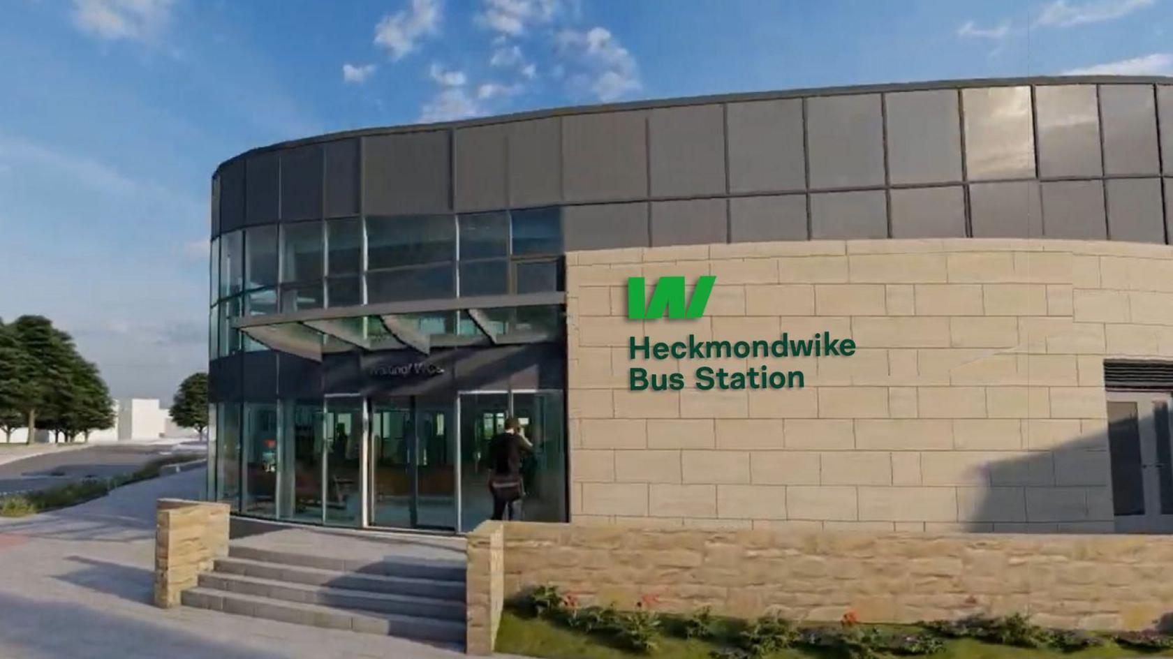 The image depicts an artist impression of the bus station, a modern structure characterized by a curved glass facade and beige stone walls. Above the entrance, a green sign reads "Heckmondwike Bus Station" alongside a matching green logo. 
A person is seen walking toward the entrance, which features glass doors.
In the foreground, there is a paved walkway bordered by greenery and flowers. On the left side of the image, trees line the street and the sky is mostly clear with a few scattered clouds.
