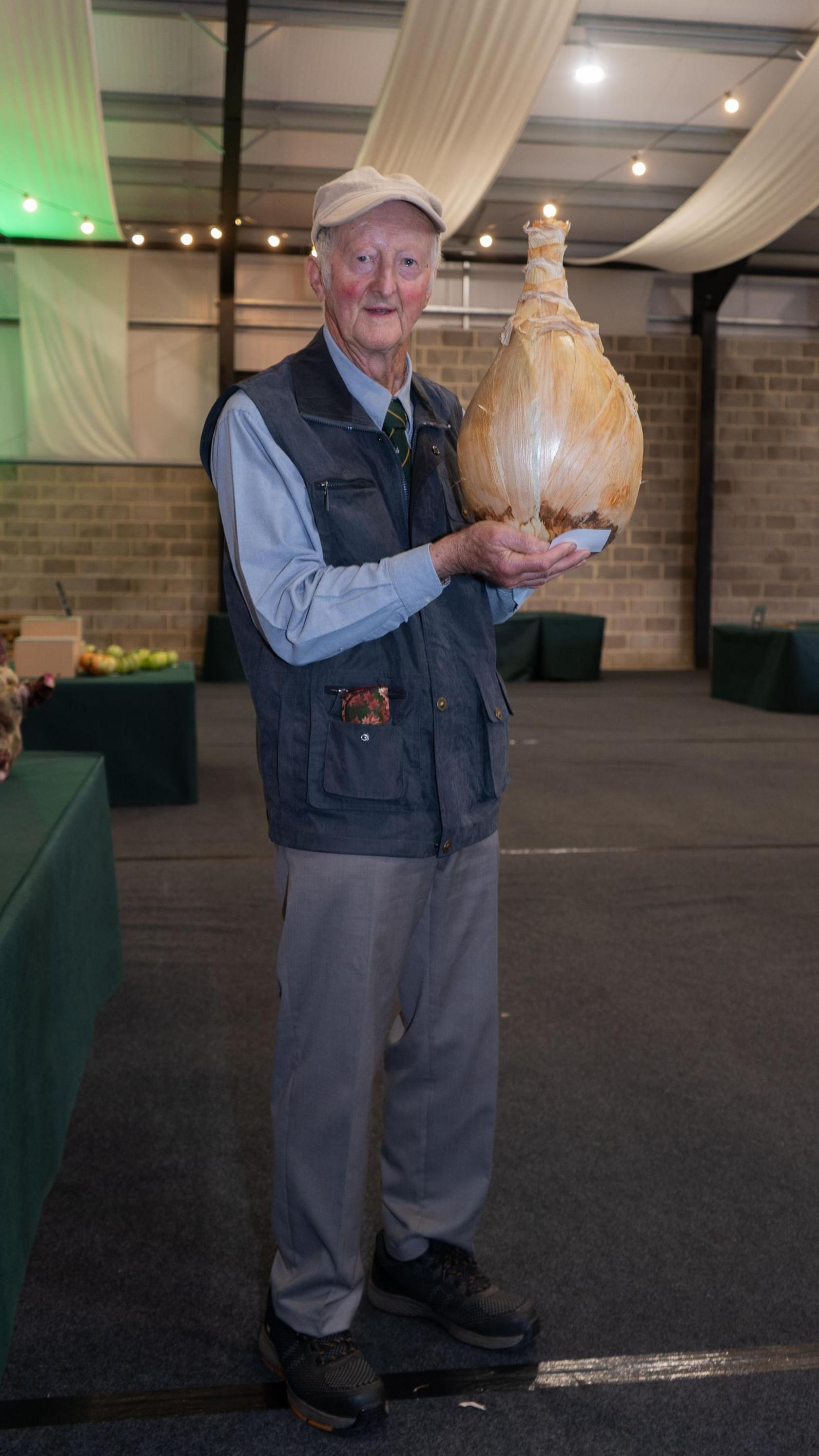 A man holding a huge onion. 