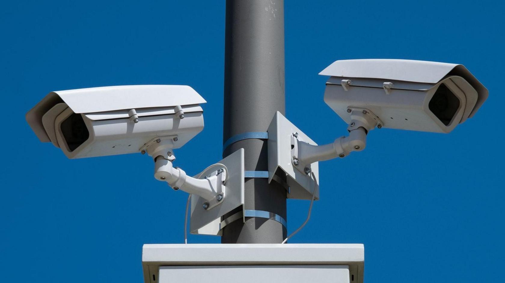 A stock photo of surveillance cameras are directed in different directions, conduct continuous shooting and video surveillance on the city street.