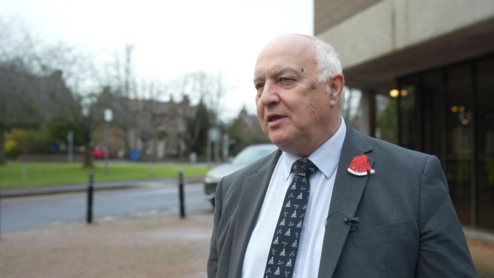 Bill Lobban ann an deise air beulaibh thogalaichean na Comhairle